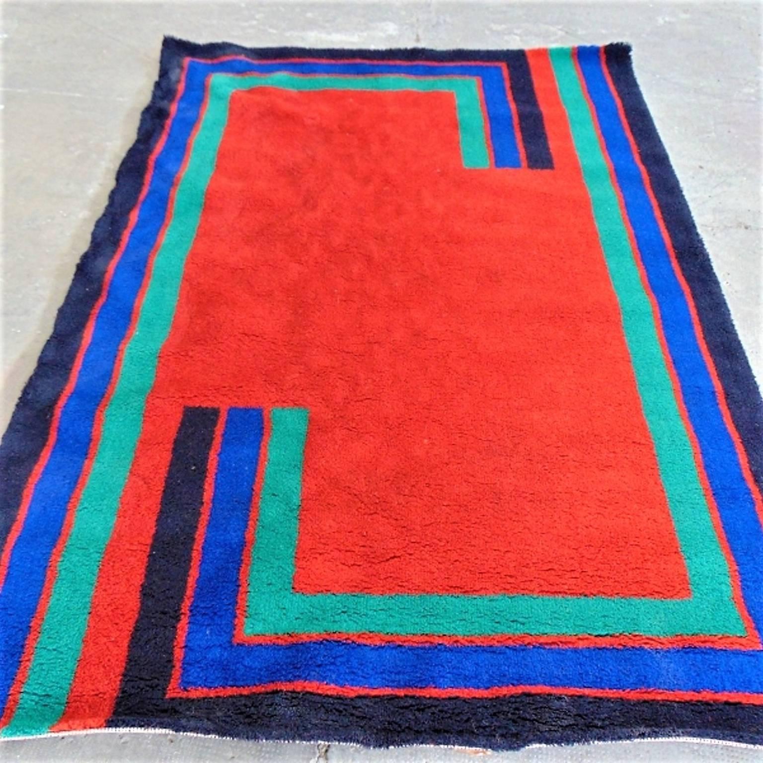 Pure new wool geometric carpet with the famous technique created by Marguerite Rye.
Color combination: dominating color is red, with geometric stripes around the carpet in dark blue, China blue and turquoise.
The carpet is a bit wavy, but with a