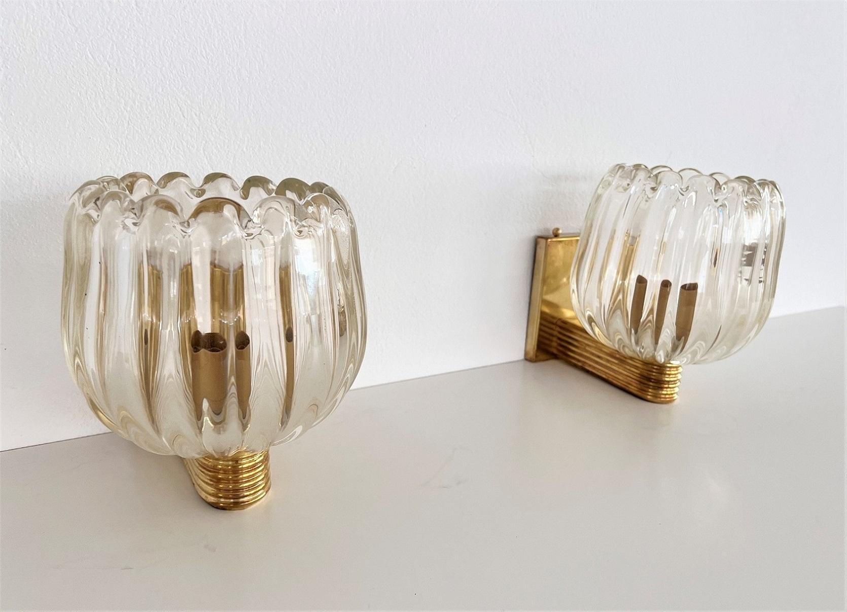 Beautiful set of two gorgeous brass wall lamps made of strong brass base and light amber-transparent Murano glasses with golden shimmer/glitter inside the glass. Art Deco style.
Made in Murano, Venice, Italy.
The brass is partially with gorgeous