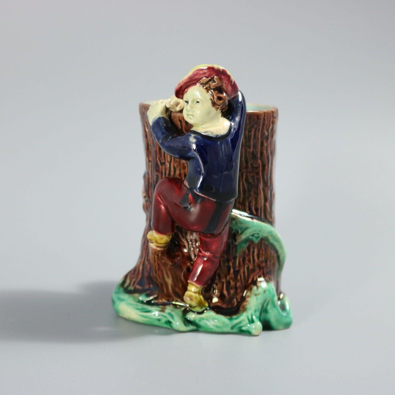 Vaso in maiolica Holdcroft con un ragazzo che si arrampica su un albero. Colorazione: predominano il marrone, il rosso e il verde. Porta un numero di modello, '338'.
