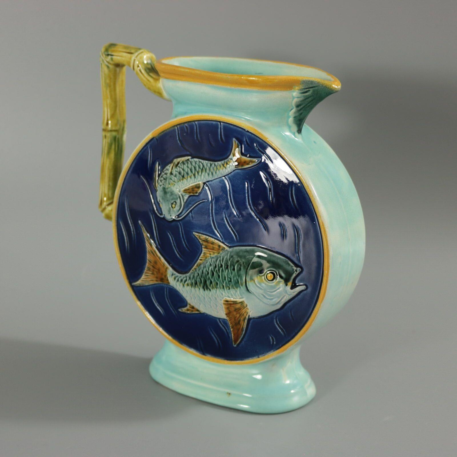 Holdcroft Majolica jug/pitcher which features two fish (carp) swimming and a bamboo handle. Colouration: cobalt blue, turquoise, brown, are predominant. The piece bears maker's marks for the Holdcroft pottery. Bears a pattern number, '79'. English