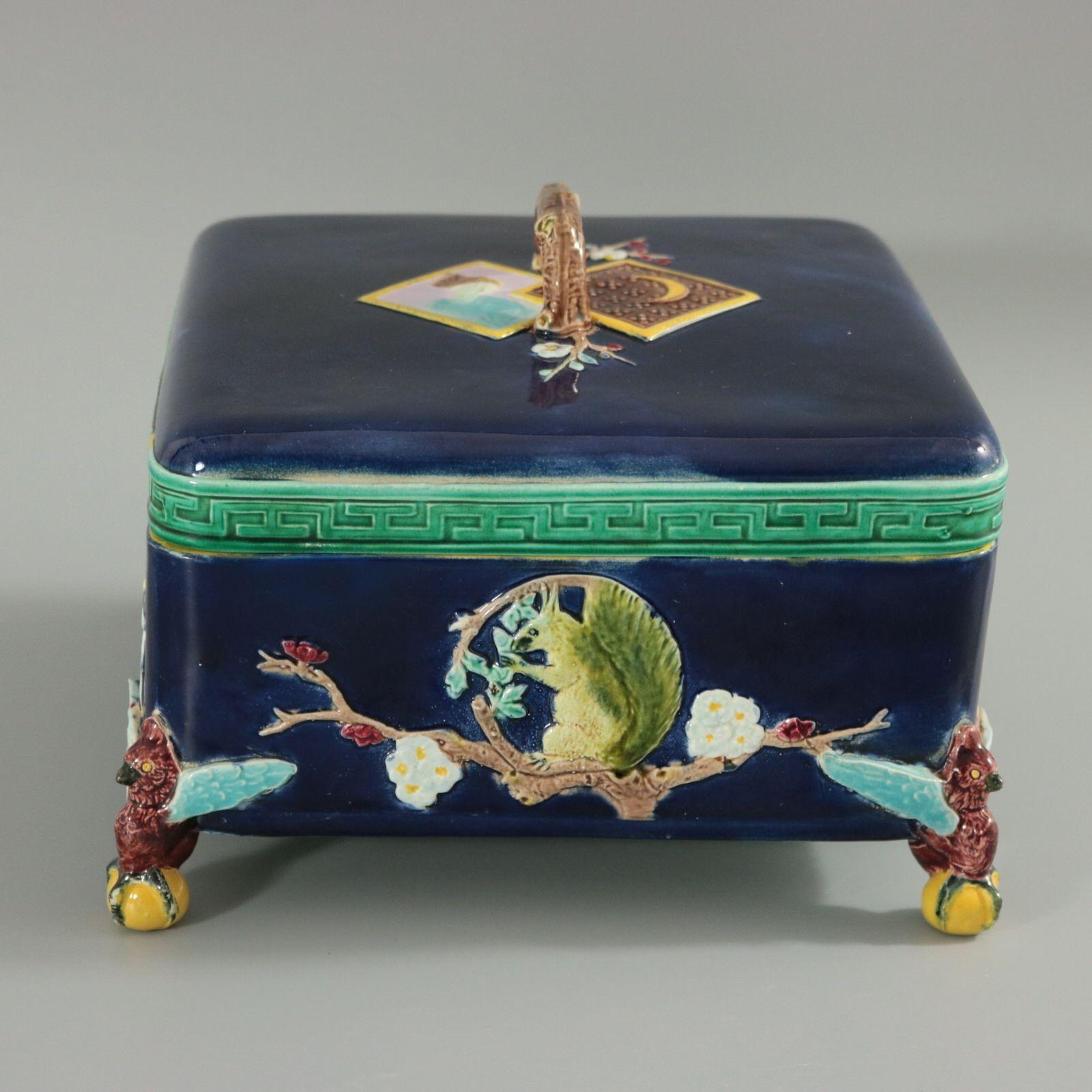 Holdcroft Majolica square box and cover which features storks, squirrels, blossom and parrot feet. Coloration: cobalt blue, green, turquoise, are predominant. The piece bears maker's marks for the Holdcroft Pottery.