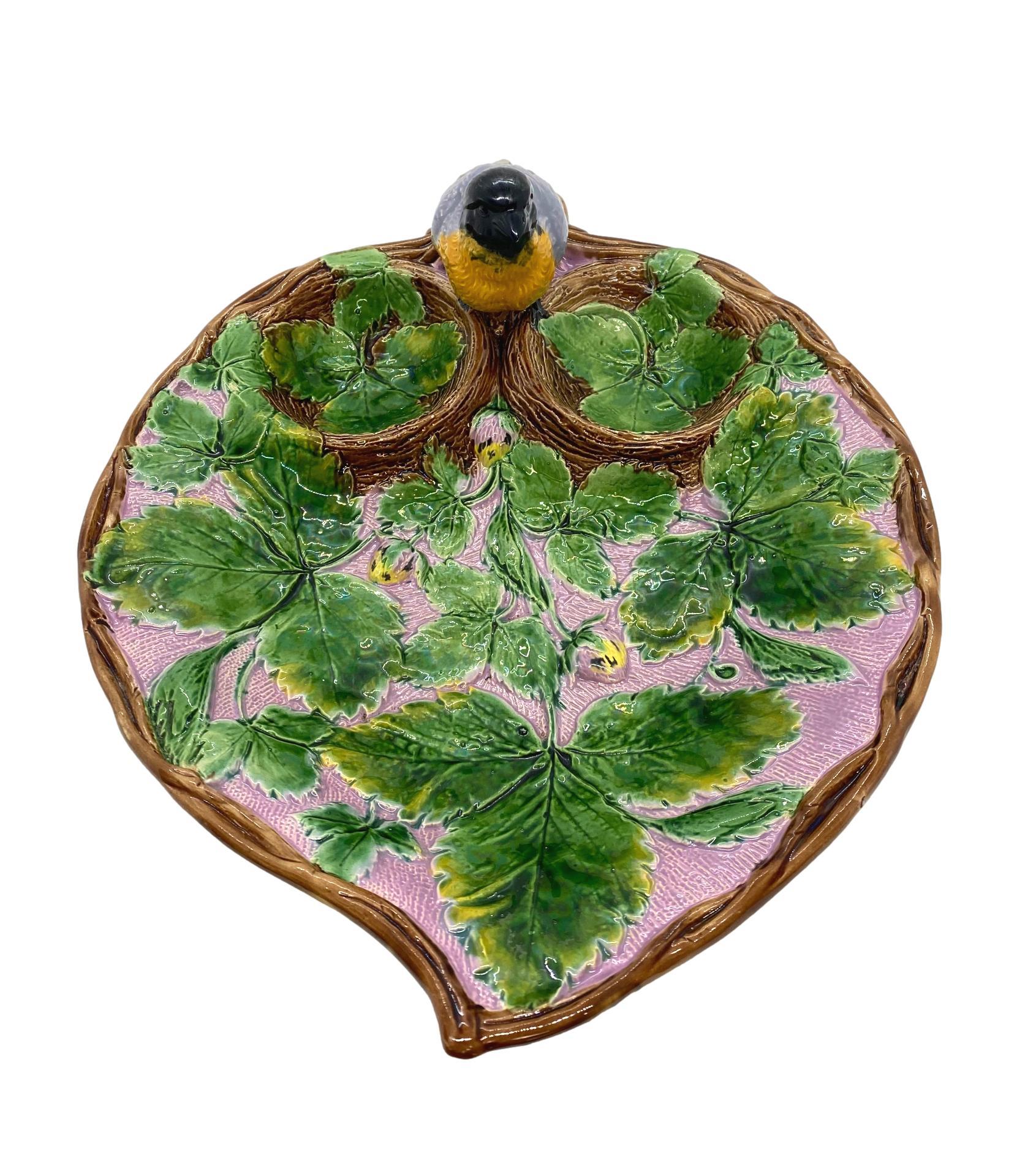 Holdcroft Majolica Strawberry Server, the relief molded dish of leaf form with green glazed strawberry leaves, with pink and yellow glazed strawberries, the cream and sugar wells naturalistically molded as birds' nests, each lined with strawberry