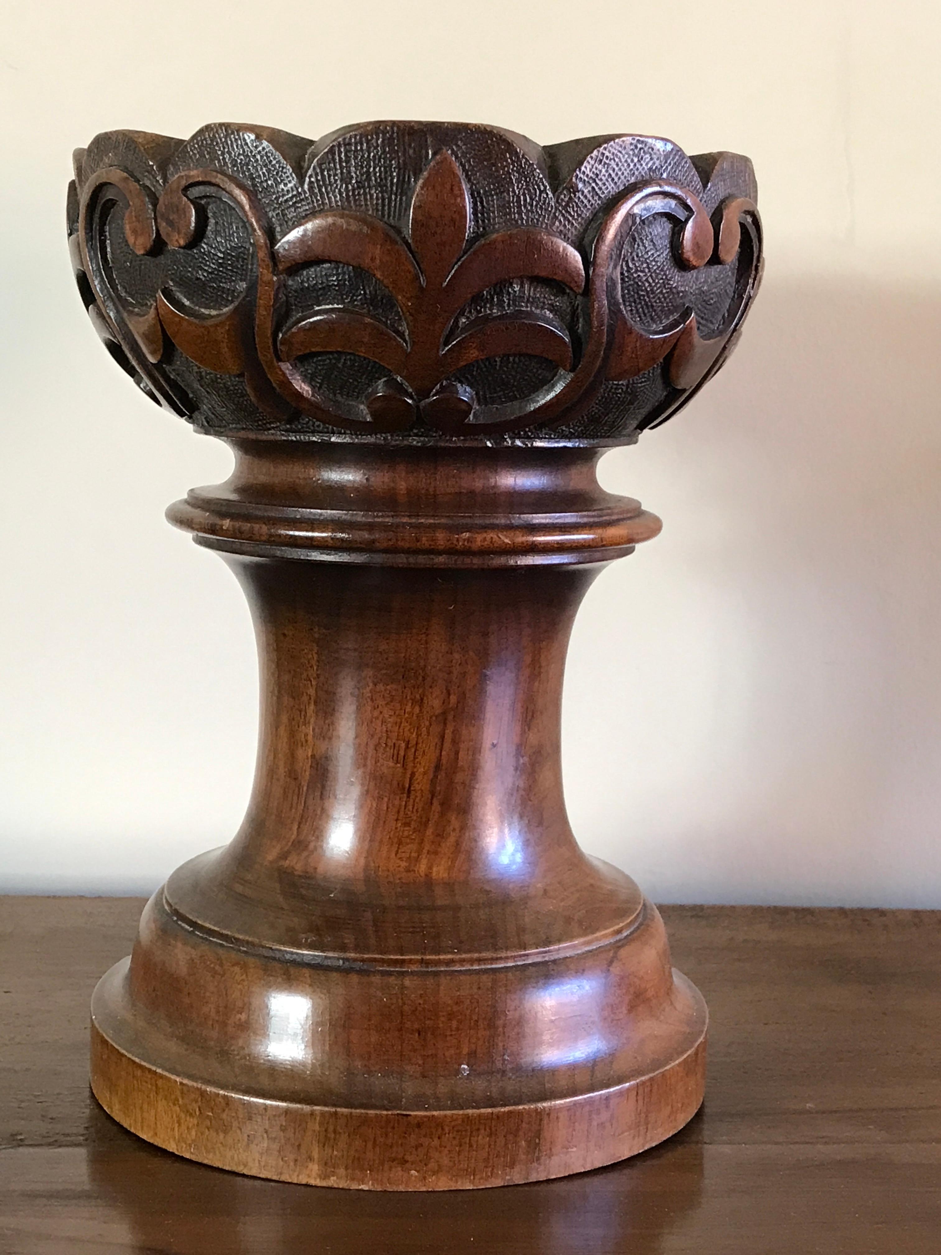 Re-purposed as a holder for large candle or delicacies.

Conceived as a Gothic Revival architectural ornament probably a finial. Shaped top with a border of scrollwork and stylised leaf carving above a turned base.
outer diameter 18cm., 7