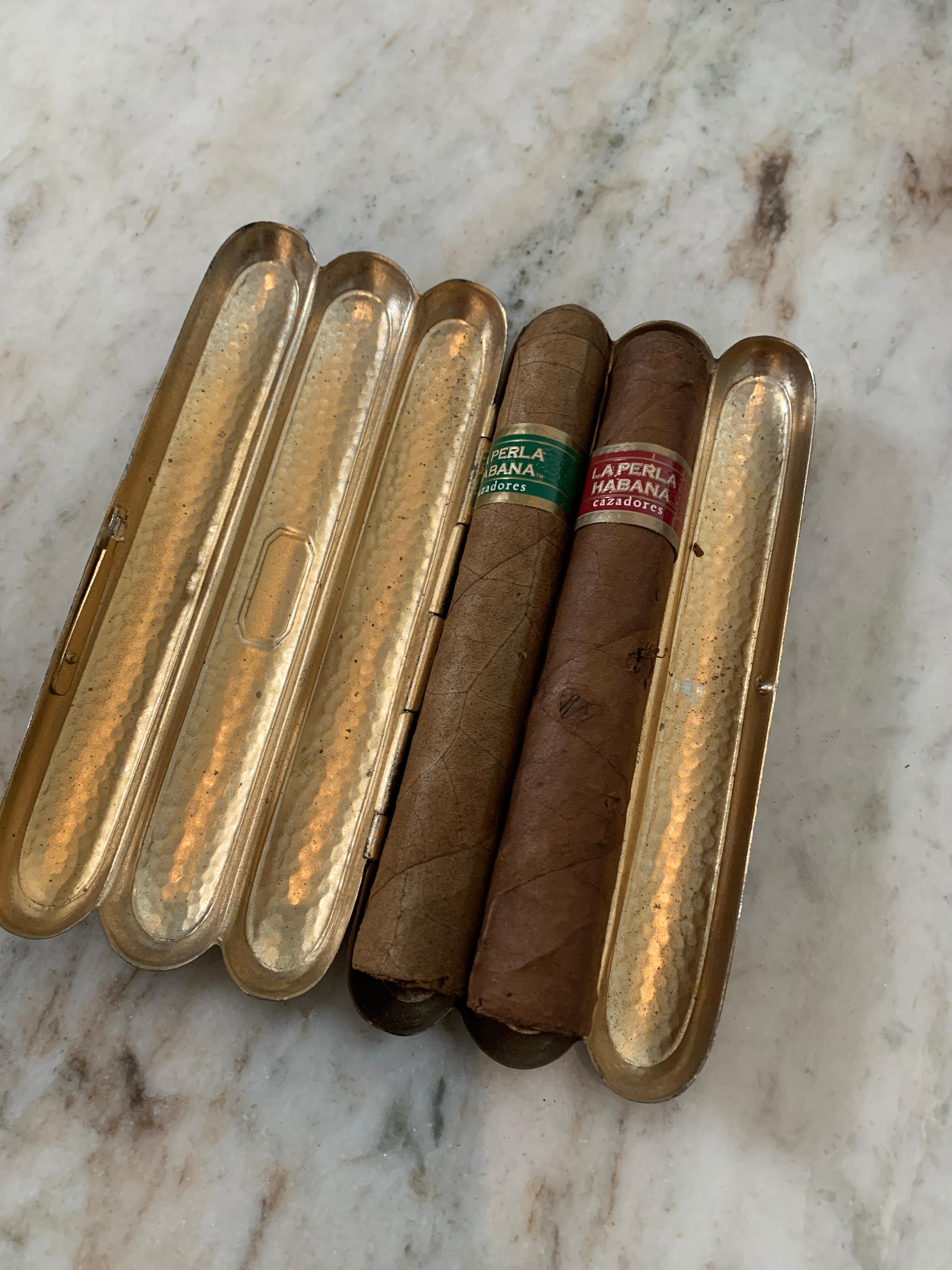 A wonderful case for three cigars of your choice... cuban, hand rolled... you name it.

Tin case is perfect place to stash three for the game, dance or long weekend. 
The piece locks as not to lose any of your preferred smokes.