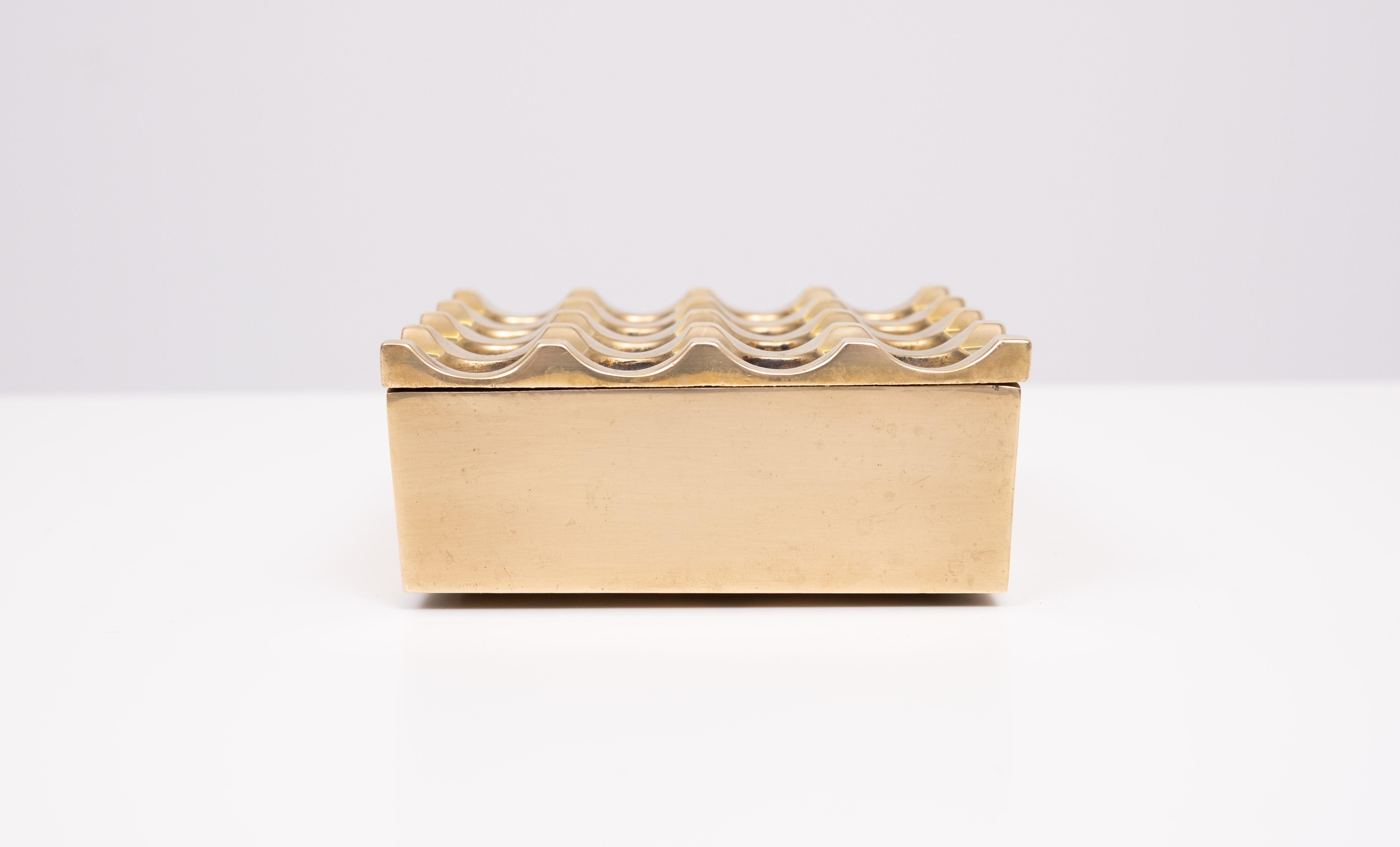 Il famoso posacenere Ultima dell'azienda svedese Beck & Jung. Celebre design geometrico degli anni '70 di Holger Bäckström & Bo Ljungberg. Grande pezzo vintage, realizzato in due parti di ottone massiccio.

