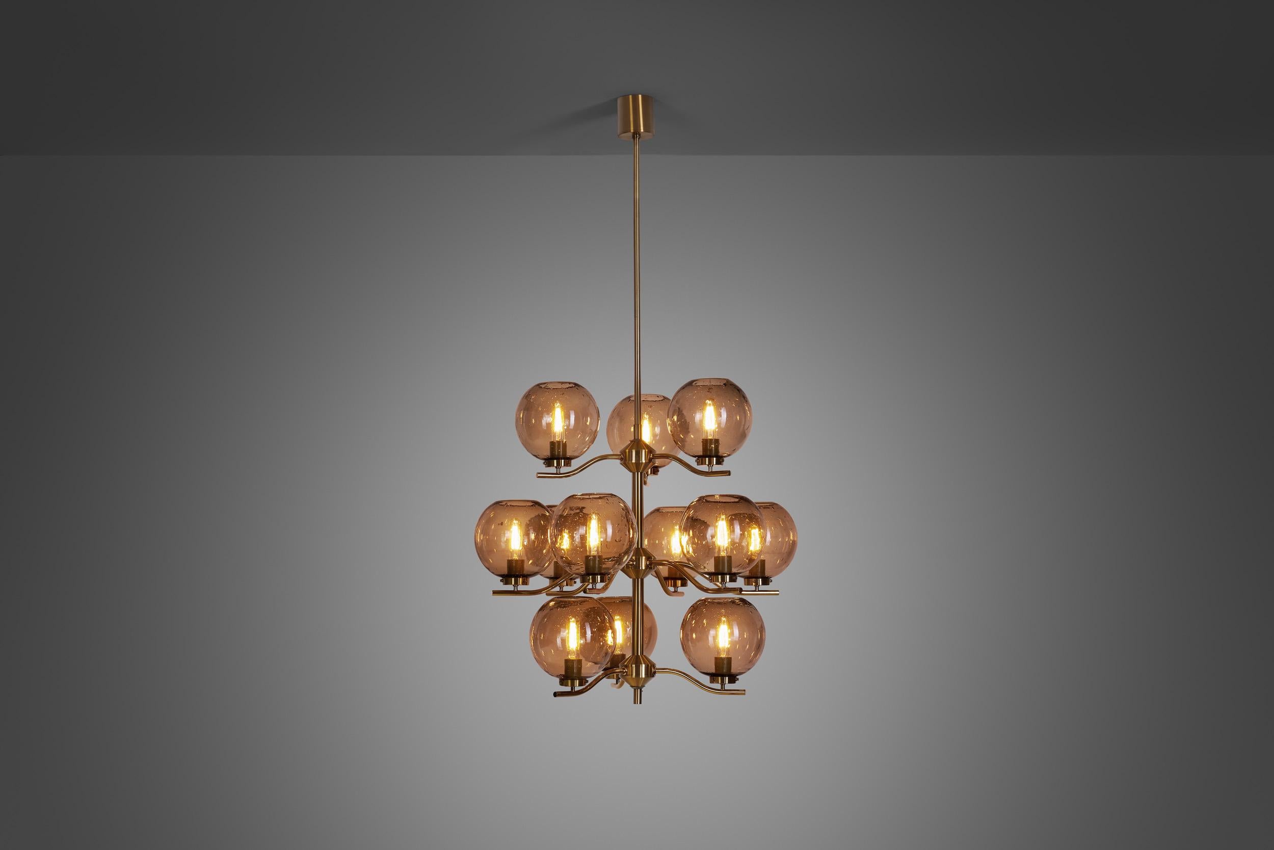 This marvellous chandelier is a rarity from Swedish designer, Holger Johansson, who created it for his own company, Westal. With a brass frame holding 12 translucent bubble glass shades, grandiose and stylish are the words to describe this model
