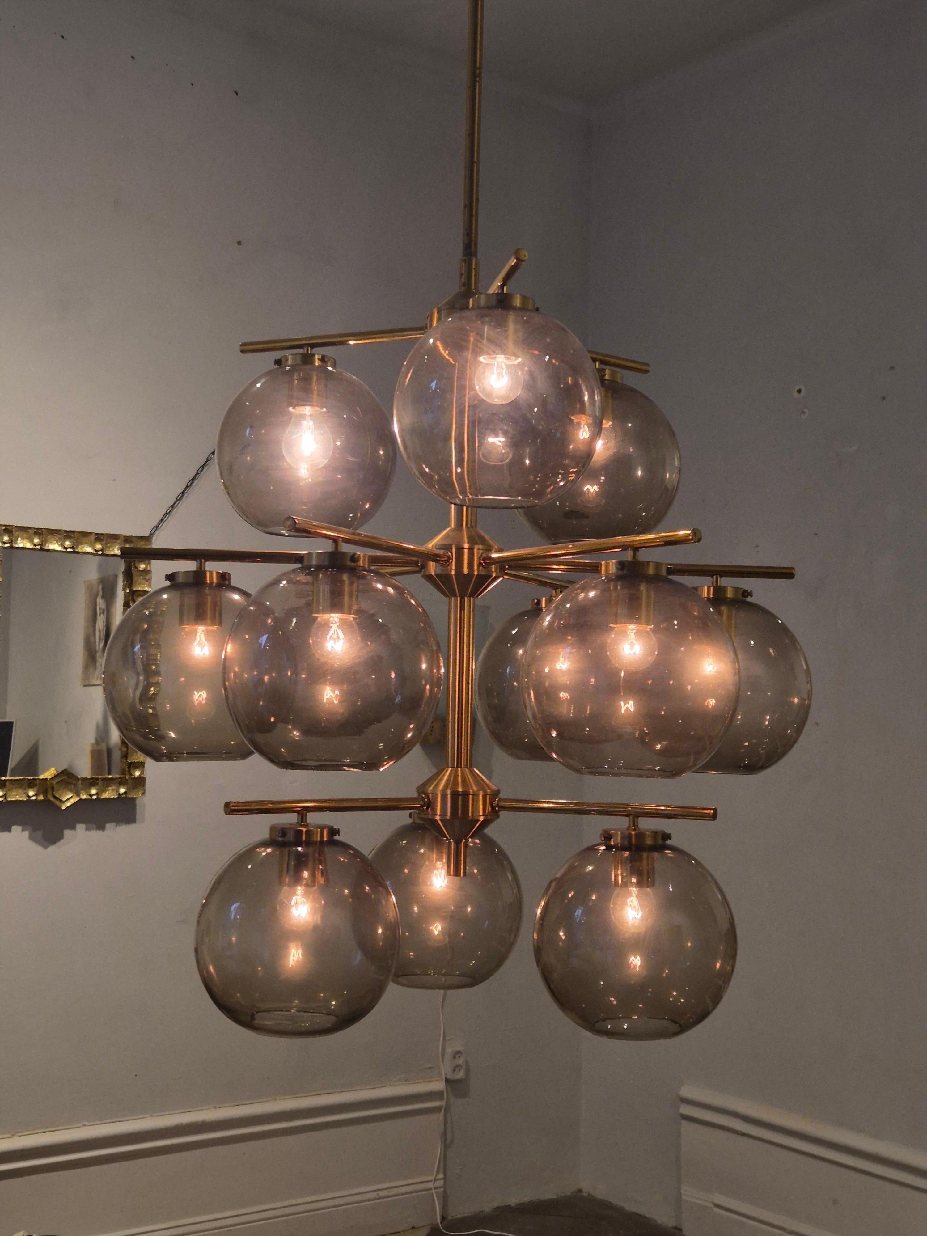 A beautiful chandelier from a church (now private residence) on Gotland, Sweden, in brass with grey transparent shades.  

Designed by Holger Johansson for Westal, Bankeryd, Scandinavian / Swedish Modern mid-1900s. 

Two are available. In good