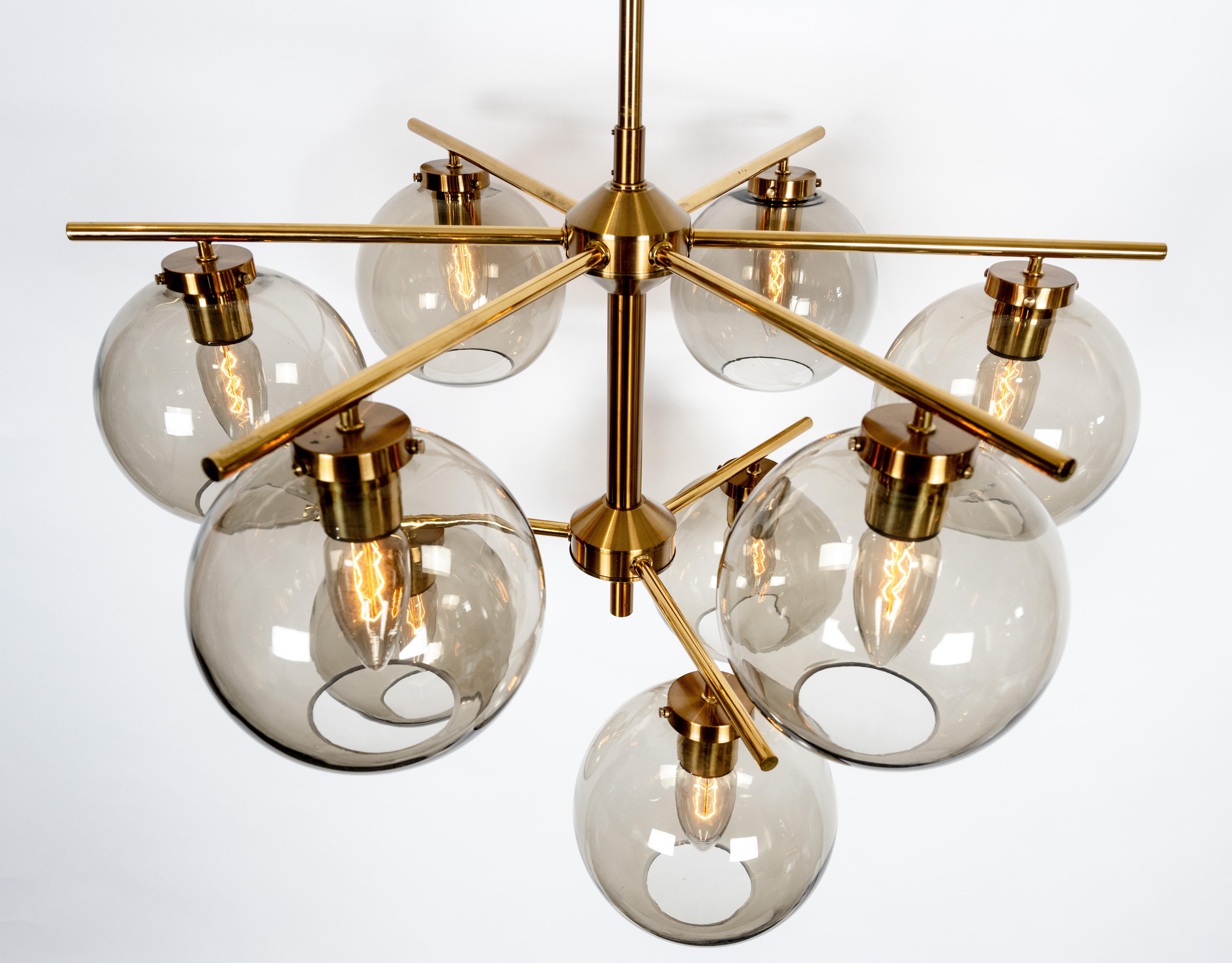 Un rare ensemble de quatre luminaires de plafond à neuf lumières de design contemporain conçus par Holger Johansson. Les cadres en laiton, légèrement patinés et laqués, sont dotés d'abat-jours ronds en verre fumé, chacun dissimulant une douille