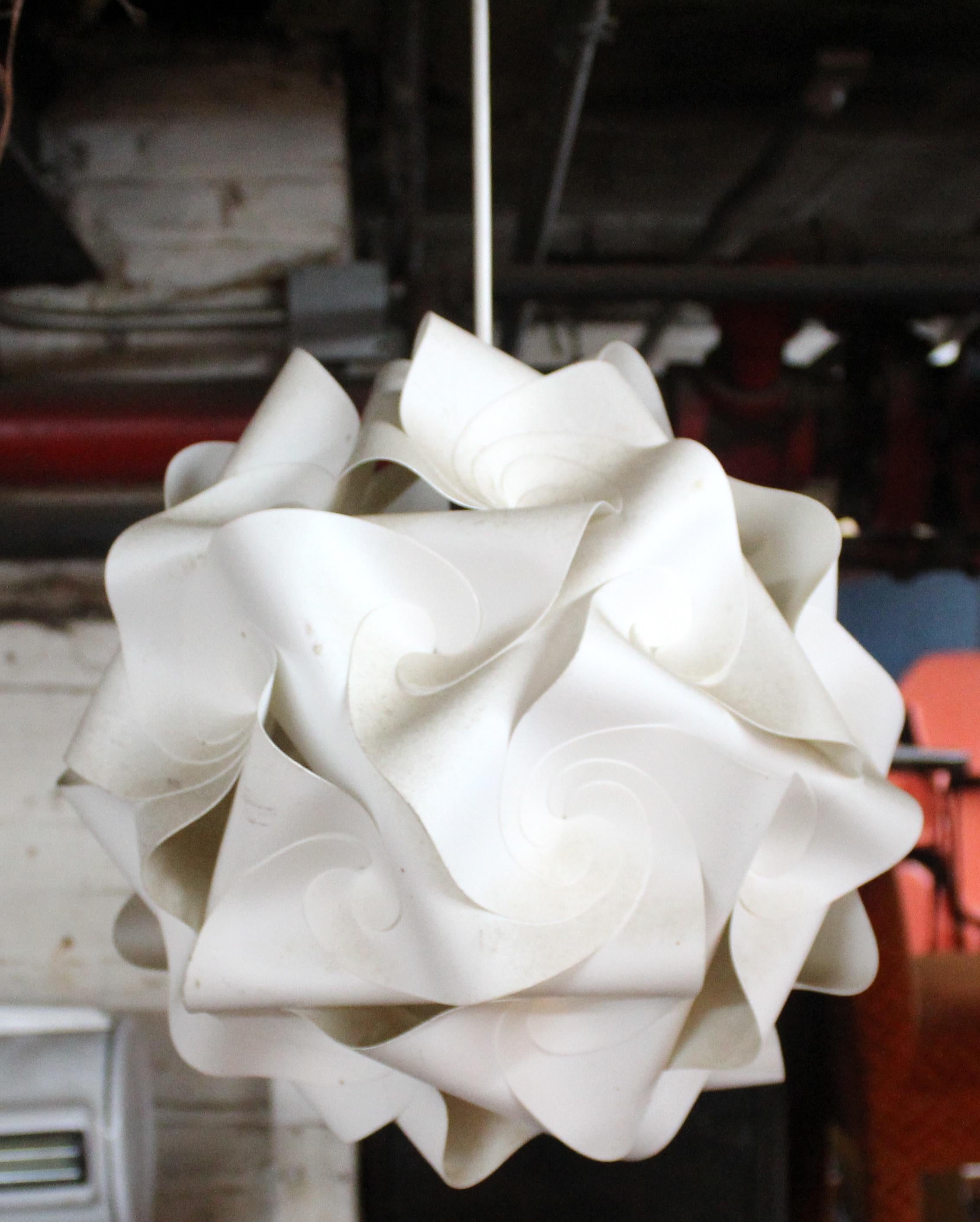 Sculptural and striking, this Mid-Century Modern pendant was originally designed by Holger Strøm, and features a dynamic ribbon-style design crafted from molded plastic. Its flowing, layered form diffuses light beautifully, casting warm, ambient