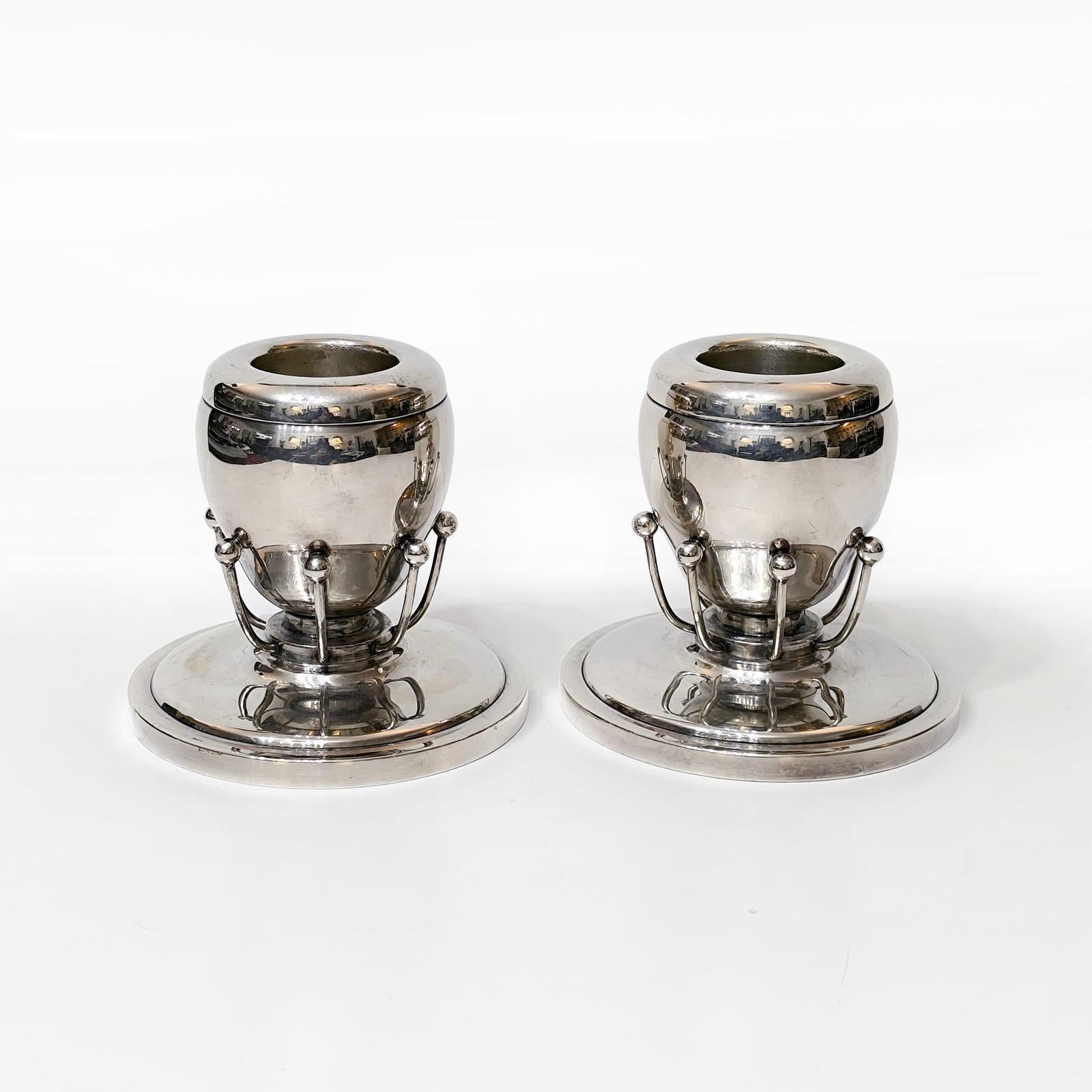 Seltenes Paar Kerzenständer aus Silberblech im Stil von Georg Jensen.
Ein Paar Kerzenständer aus Silberblech, die an das Design von Georg Jensen erinnern.
Die leichte Schale ist elegant eiförmig und bis zum Boden von einem zarten Kranz aus