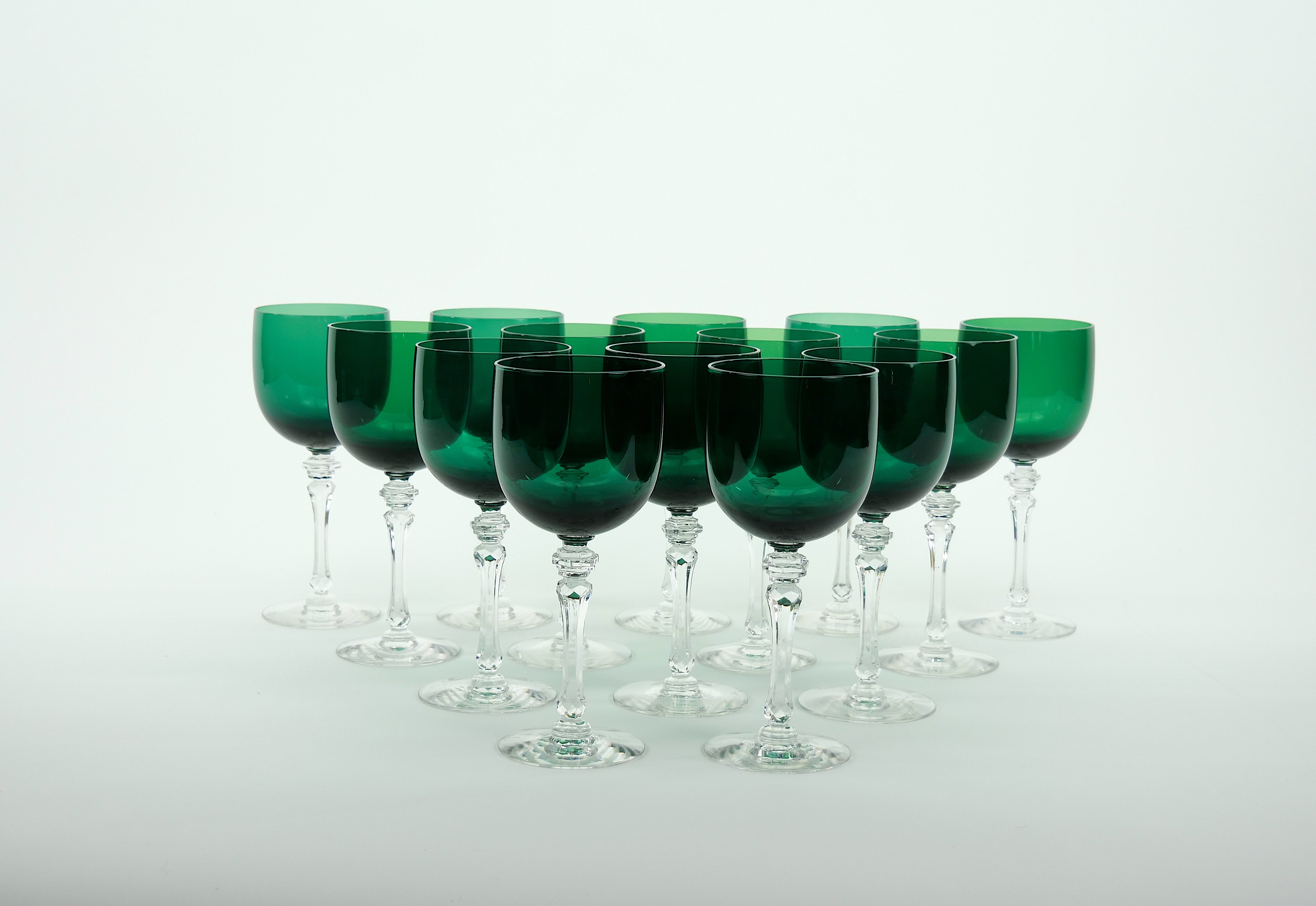 Exquisite holiday green colored crystal with clear cut stem early 20th century Franciscan tableware / barware wine and water glassware service for 14 people. Each glass is in excellent vintage condition. Each glass measures 7.75 inches tall and 3