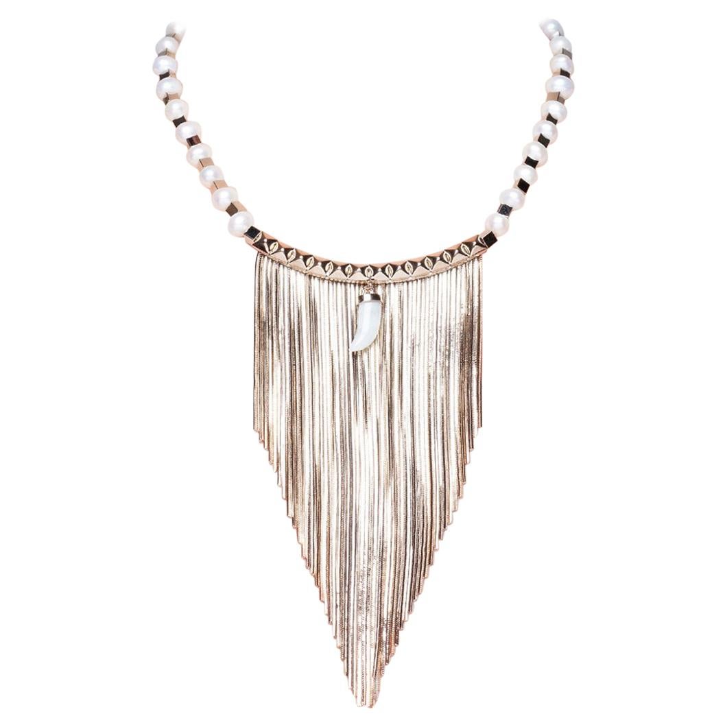 Bringing bohemian elegance to bib necklace, this fringed necklace from IOSSELLIANI features freshwater pearls alternated with gilded geometric brass beads. The piece is further enhanced by a studded central part with a jade horn shaped charm for an