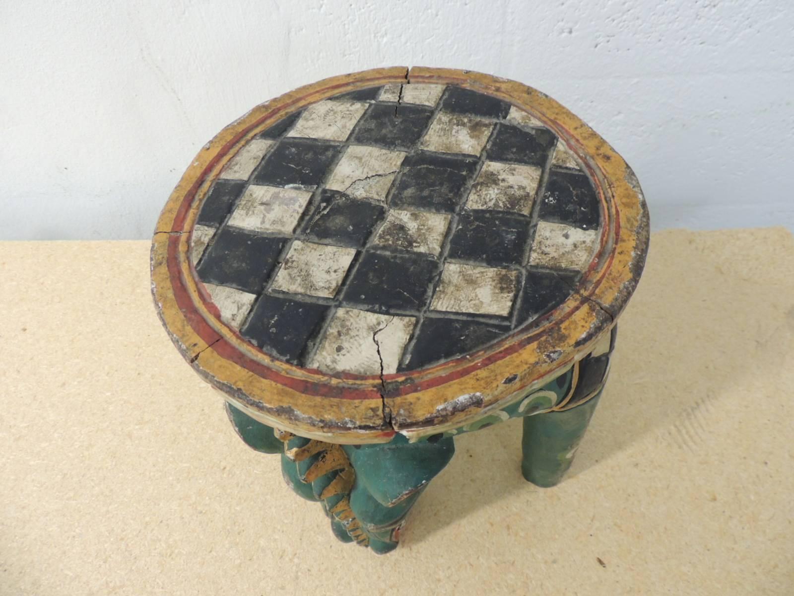 Indonesian artisanal vintage round stool Animalia style
handcrafted and hand-painted vintage Animalia style round stool with gold leaf accents and a checkerboard round design on the top. Legs carved to look like an animal. Vintage artisanal stool