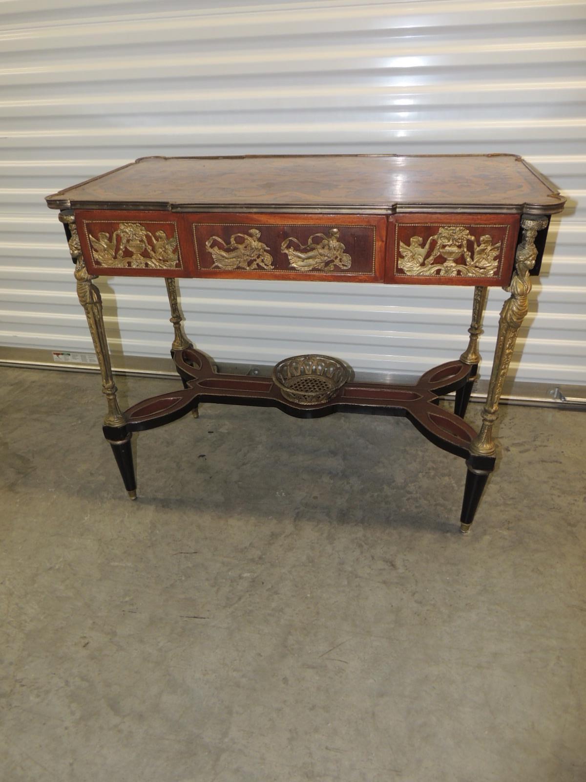 Vintage reproduction of Louis XVI style center table
French style oyster veneer wood and floral marquetry center table with
inlaid wood-top and brass ormolu details. Criss-cross stretcher and center brass basket.
Finished in all sides. The