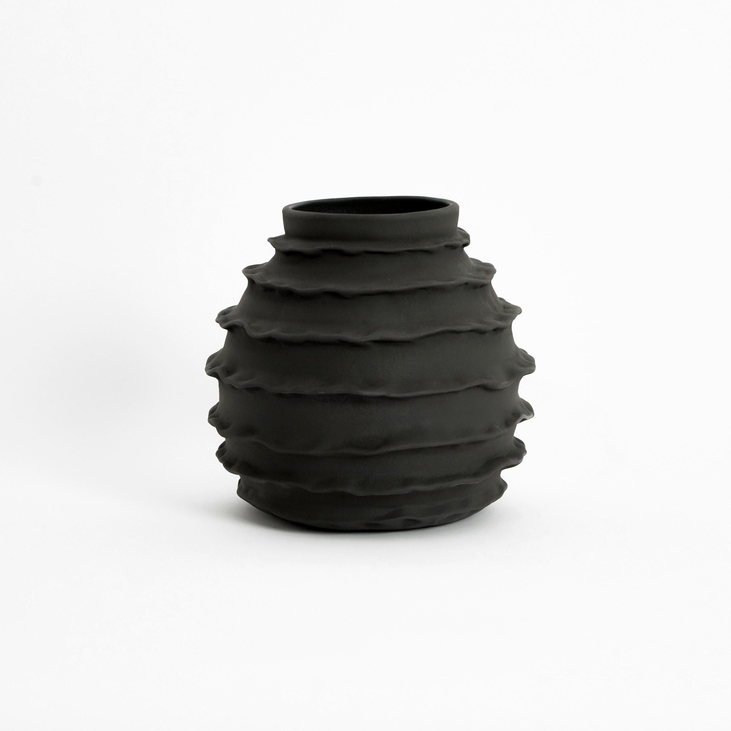 Holiday vase in dusty black.

Designed by Project 213A in 2021 Handmade Stoneware.

The oval vase, ruffled on the edges brings about contrast of lightness. This hand made and embellished vase is finished with a contemporary shiny white glaze