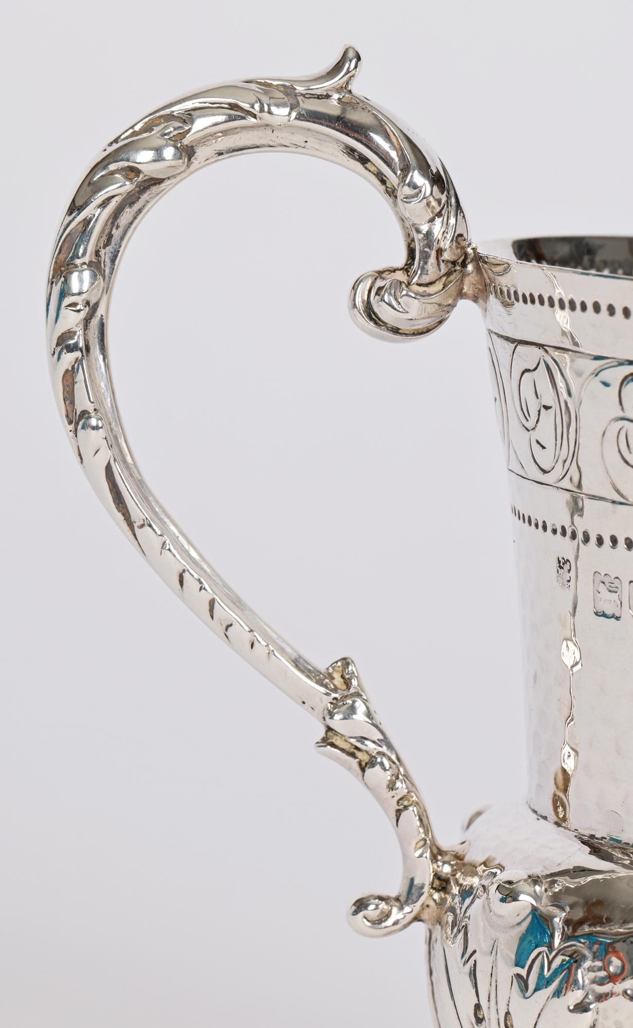 An exceptional and very impressive quality Arts & Crafts silver christening mug decorated with leaf designs by Holland Aldwinckle & Slater, London and dated 1900. The heavily made flower bud shaped mug is finely crafted standing raised on a round