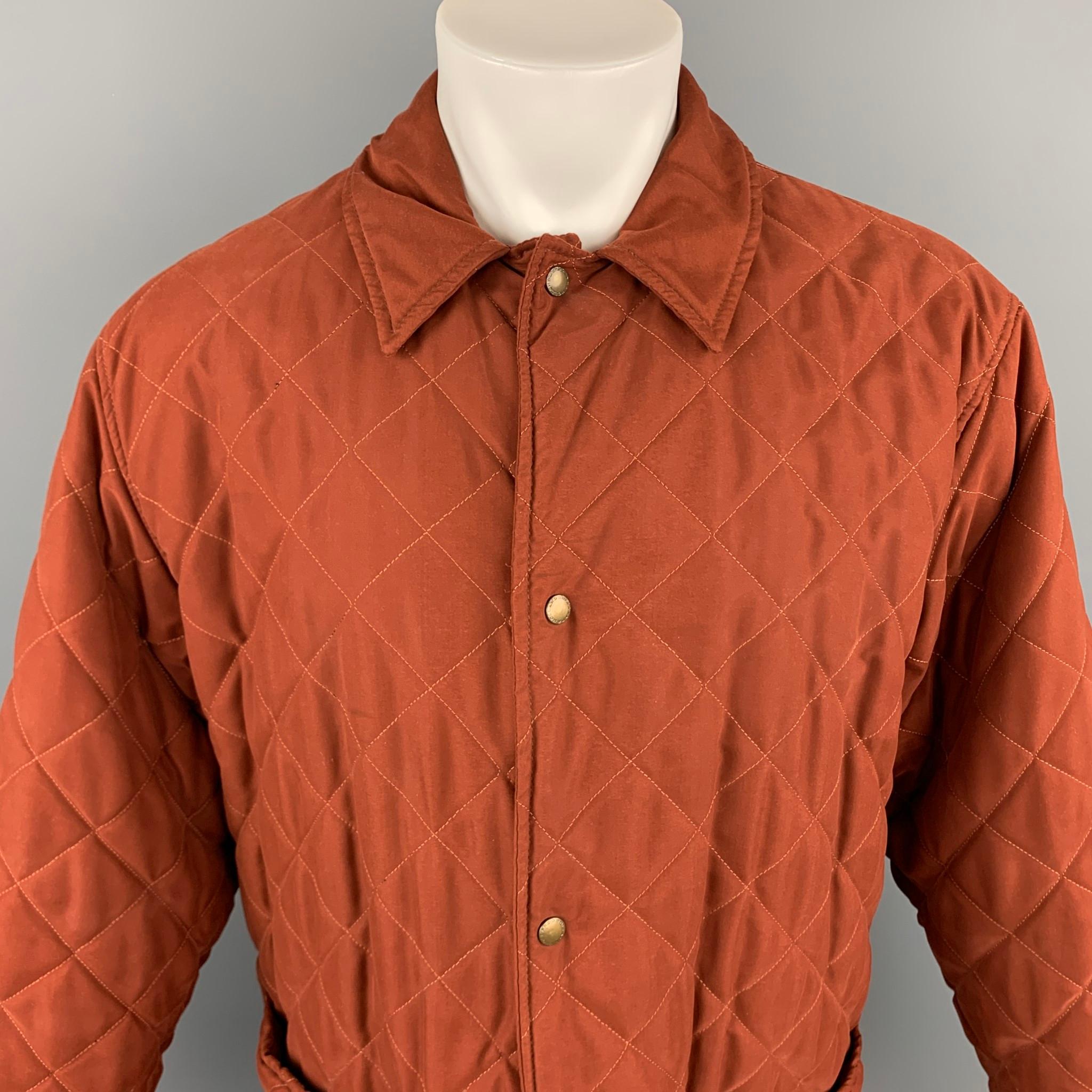 HOLLAND & HOLLAND coat comes in a rust quilted polyester with a full liner featuring a oversized fit, spread collar, patch pockets, and a snap button closure. Made in Great Britain. 

Very Good Pre-Owned Condition.
Marked:
