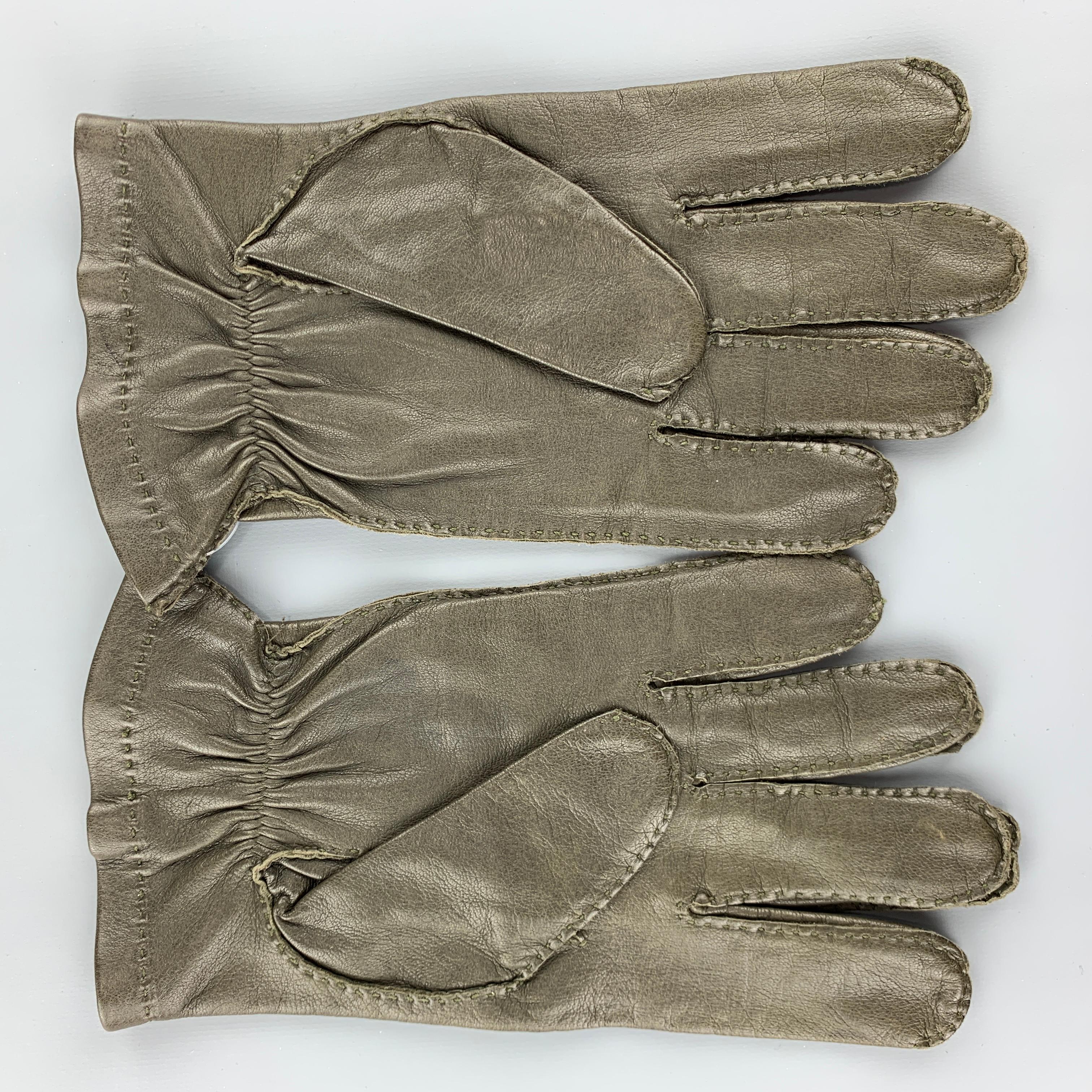 Vintage HOLLAND & HOLLAND gloves come in deep olive green leather with top stitching, elasticized cuff and silk lining. 

Very Good Pre-Owned Condition.
Marked: 8 1/2

Width: 4.25 in.
Length: 9.25 in.