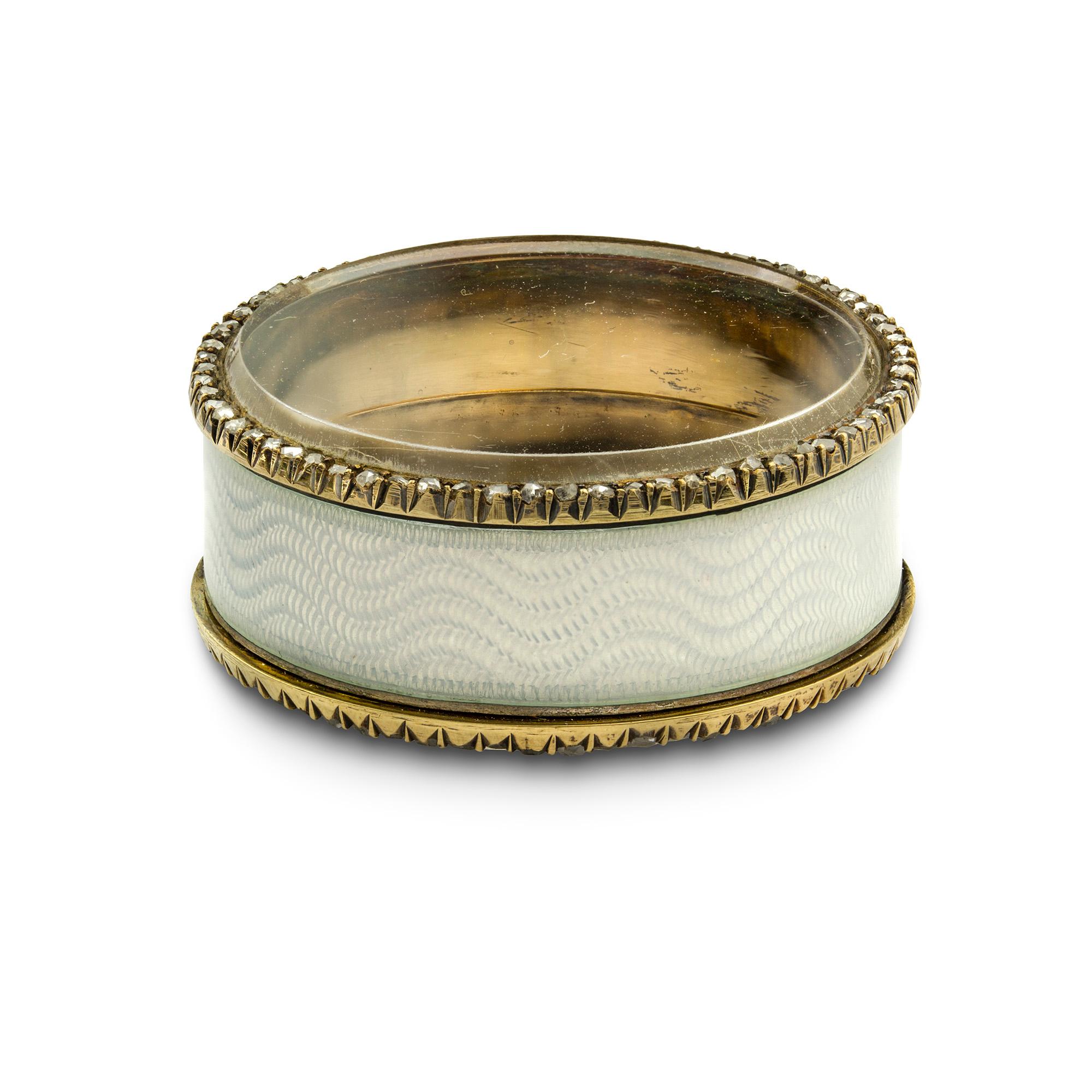 A Fabergé white enamel and diamond circular pill box, the translucent white enamel with undulating guilloché ground and circular rock crystal section to top and base, each with a rose diamond surround with silver cut-down settings, bearing the marks