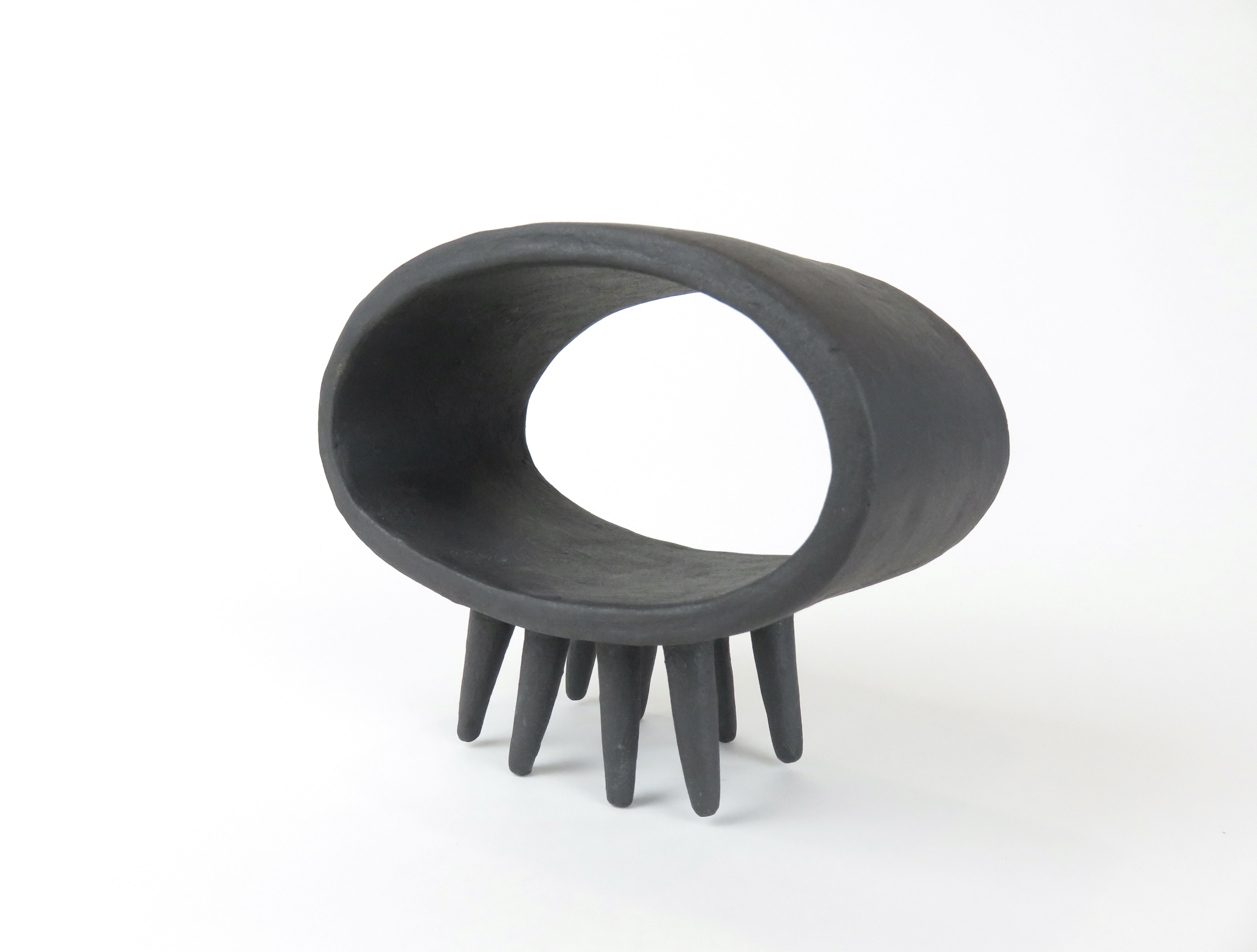 Organique Sculpture ovale creuse en céramique noire sur huit pieds pointus en vente