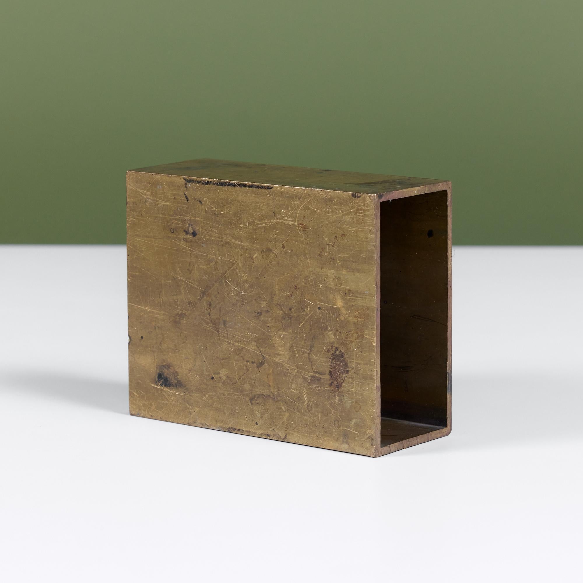 Industrial rectangular brass object. The brutalist form features a hollow center. The geometric block can be used as a bookend or decorative element.

Dimensions
﻿4