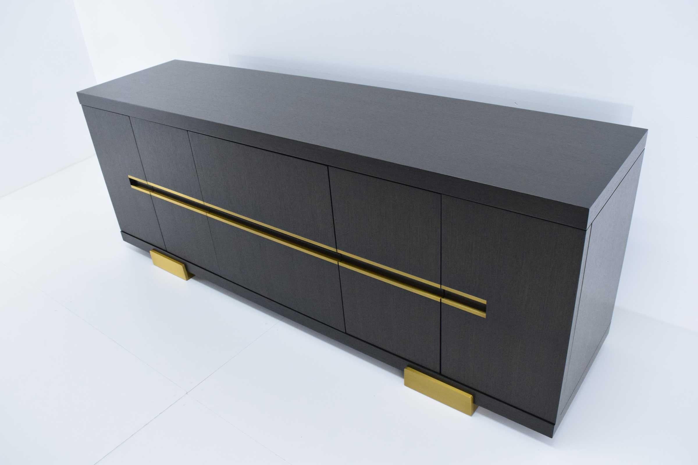 Beautiful credenza or sideboard by Holly Hunt. The Borneo credenza exhibits the finest quality in craftsmanship. Light gold finish. Two enter drawers and one adjustable shelf on each end.
