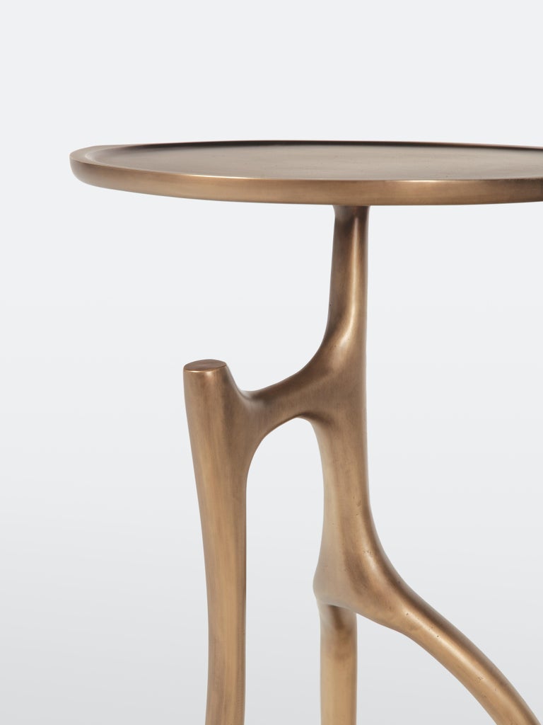 HOLLY HUNT Branche round table with cast bronze structure. The Branche Table is alive with movement and attitude. The cast bronze top perches on three distinctly different sculptural legs — telling a different visual story from every angle.