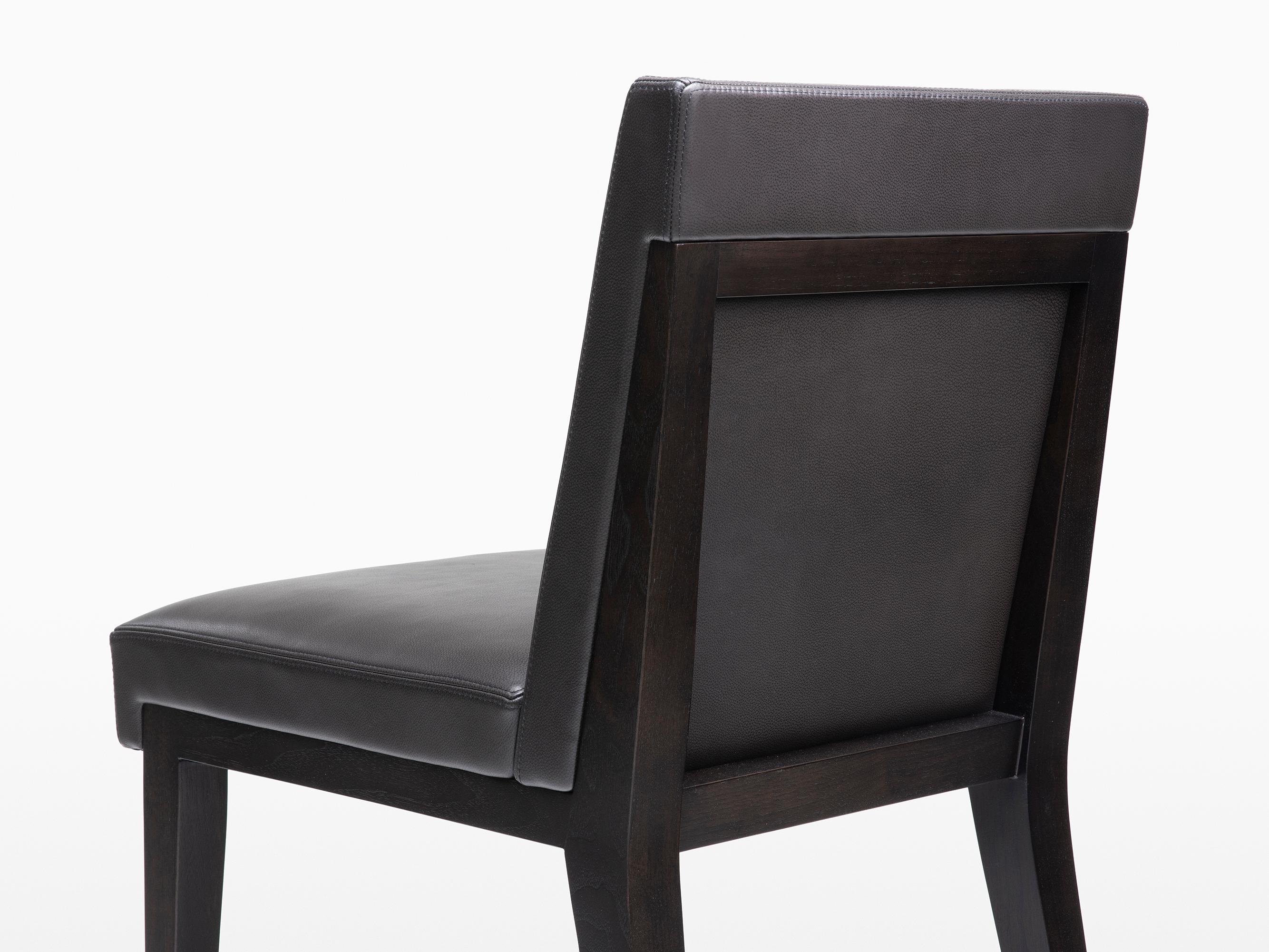 HOLLY HUNT Hampton dining side chair in walnut black magic with leather upholstery. More than just your classic dining chair, the Hampton dining arm and side chairs are crafted with extra attention to detail and quality. The upholstery goes beyond
