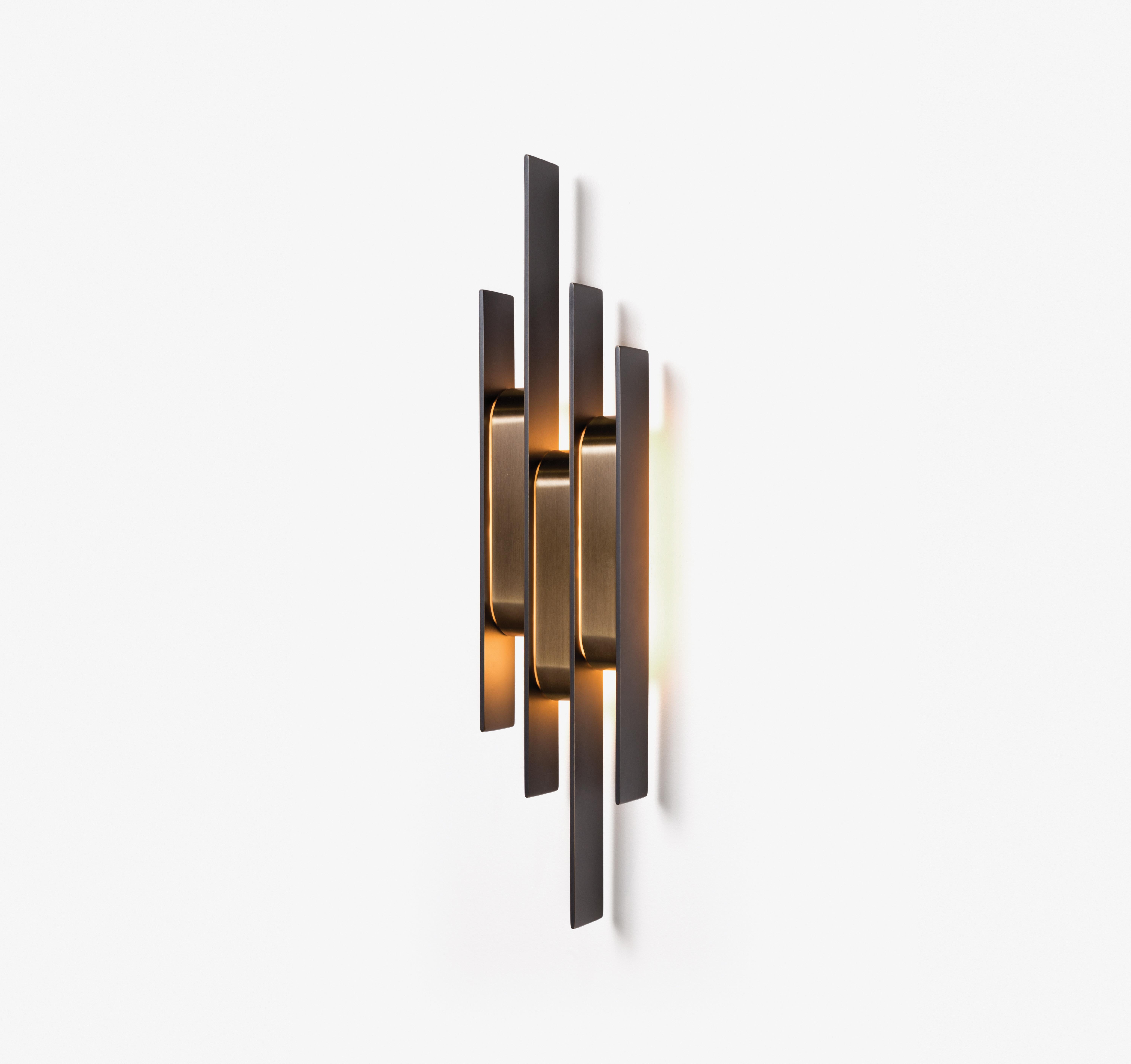 Emanating a warm, soft glow, the Meridian Sconce presents an arrangement of graphic, dark bronze verticals bridged by golden bronze shades. Asymmetrical yet rhythmic, it is a sophisticated fixture for flanking a doorway, or punctuating an expanse of