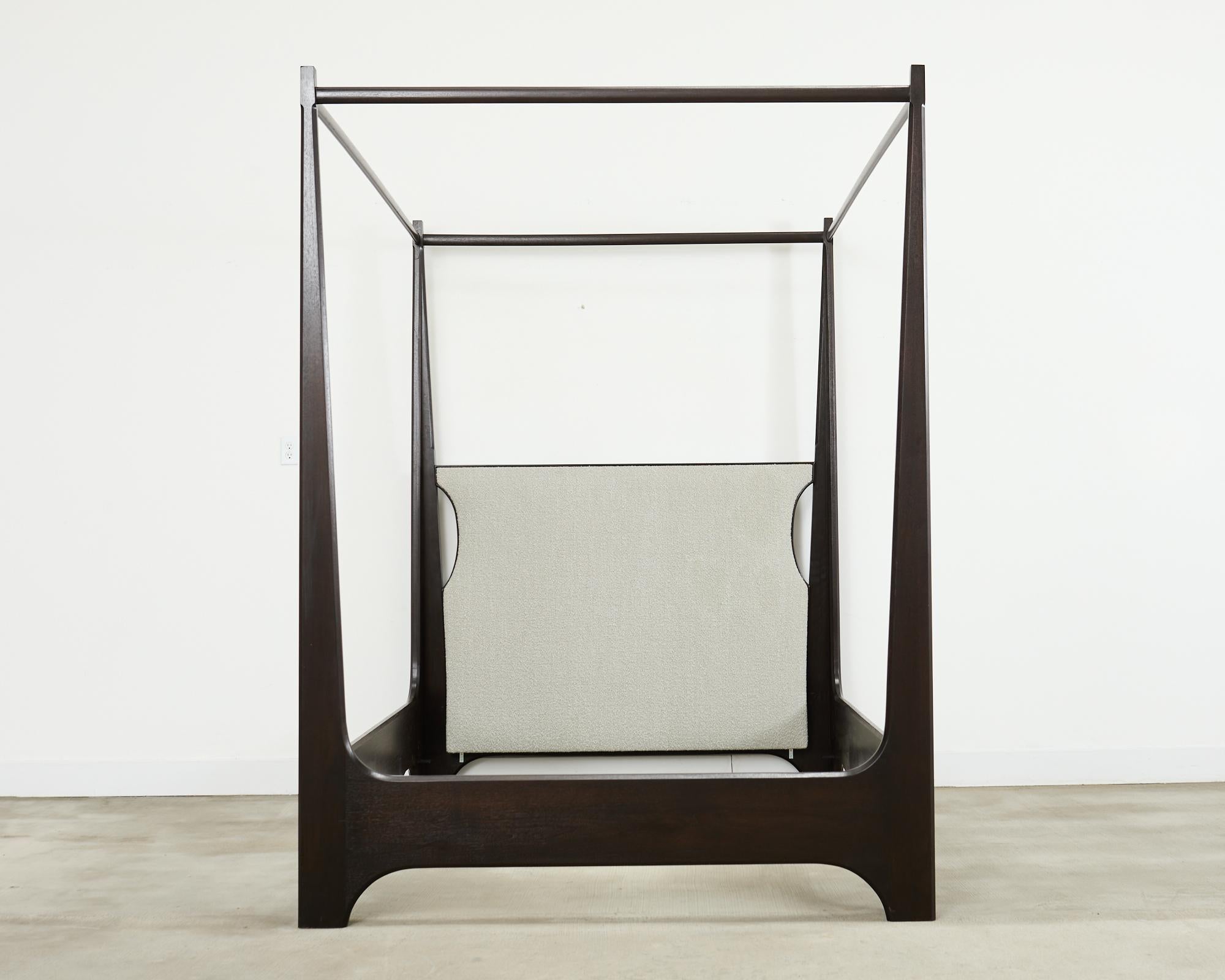 Stylish ebonized walnut four poster canopy style bed designed by Holly Hunt. The Sorraia bed is crafted from solid American black walnut on the exposed wood frame and features a dark espresso finish. The headboard is upholstered with a chic bouclé