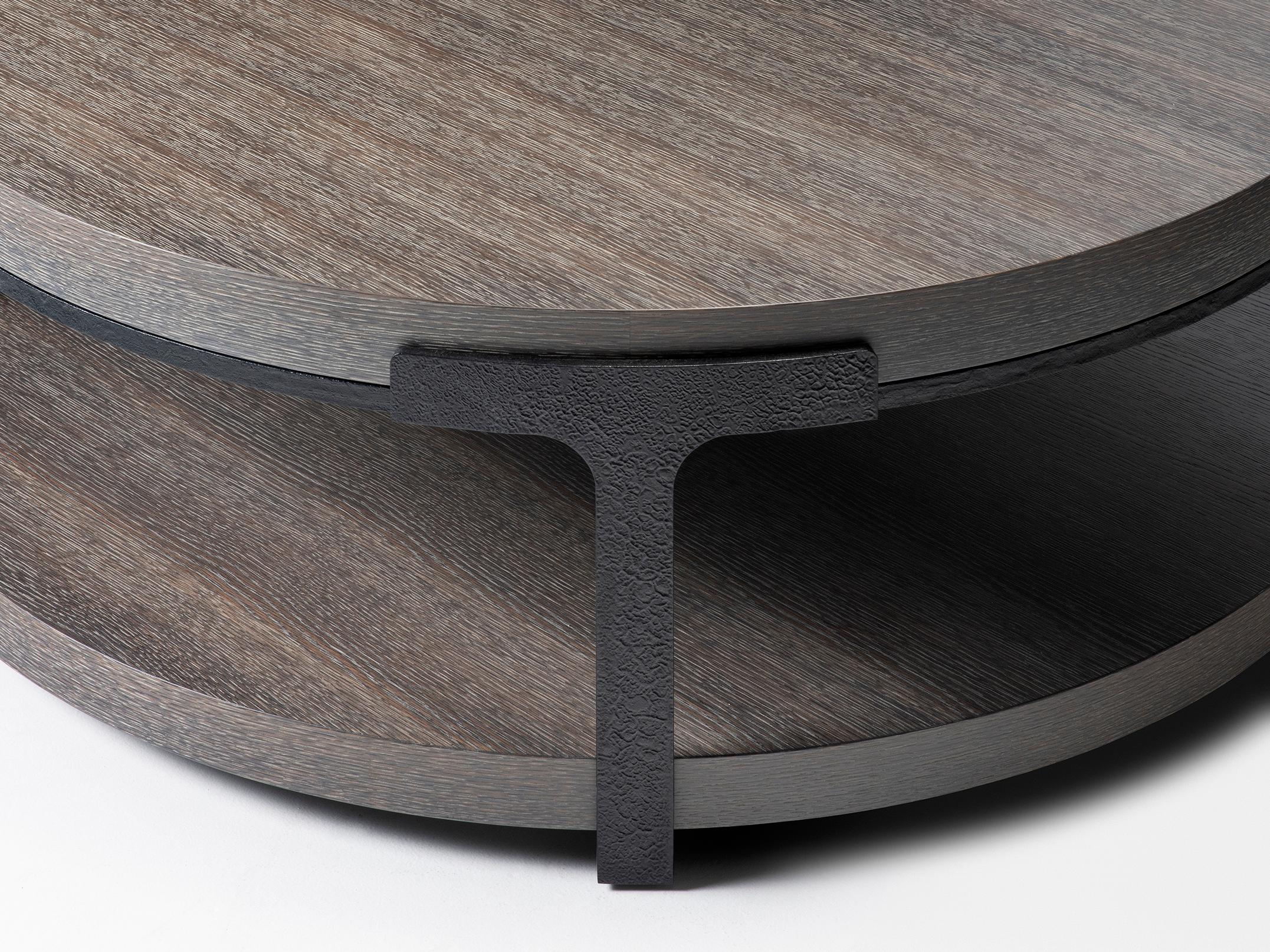 HOLLY HUNT Tudor round cocktail table with oak top and metal base. The Tudor Series is truly iconic to the HOLLY HUNT collection. Featuring hand forged iron with just the right texture to elicit interest, while still remaining clean and elegant with