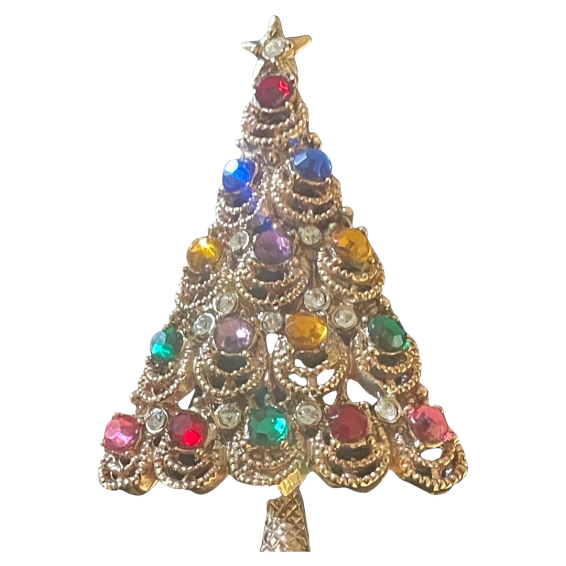 Unsigned Circa. 1938-1947 Hollycraft Christmas tree made in gold tone, with rhinestones that appear to be the lights on the tree.  Known for its pastel colors you will see the classic green and red, along with pink, purple, blue, gold, and green. 
