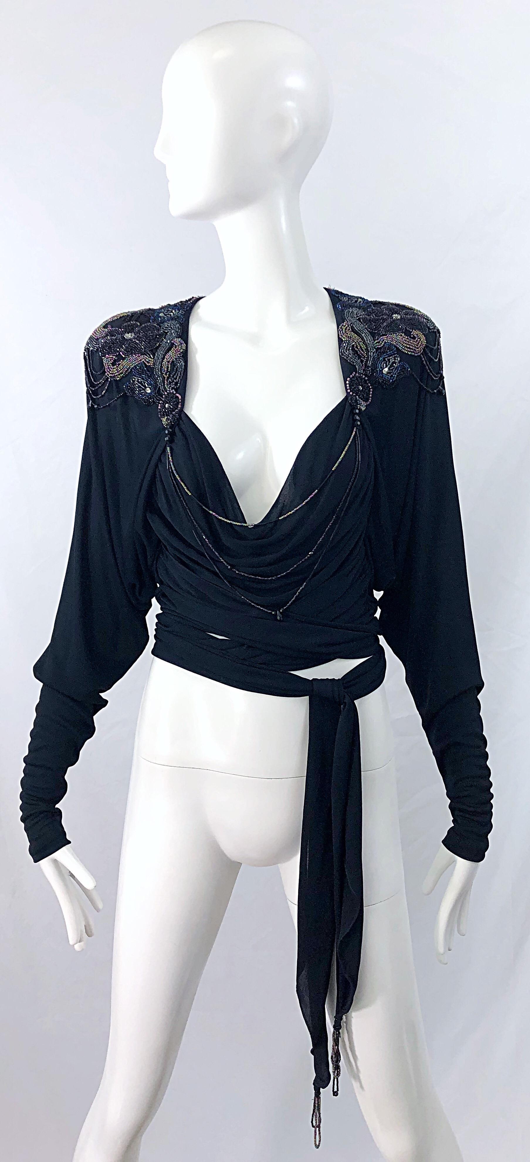 Chic late 70s HOLLY'S HARP black silk jersey beaded long sleeve wrap crop top ! Features thousands of 
hand-sewn beads and sequins throughout. Faux wrap style with sash that ties around the back and to the front. Dolman sleeves can accomodate an