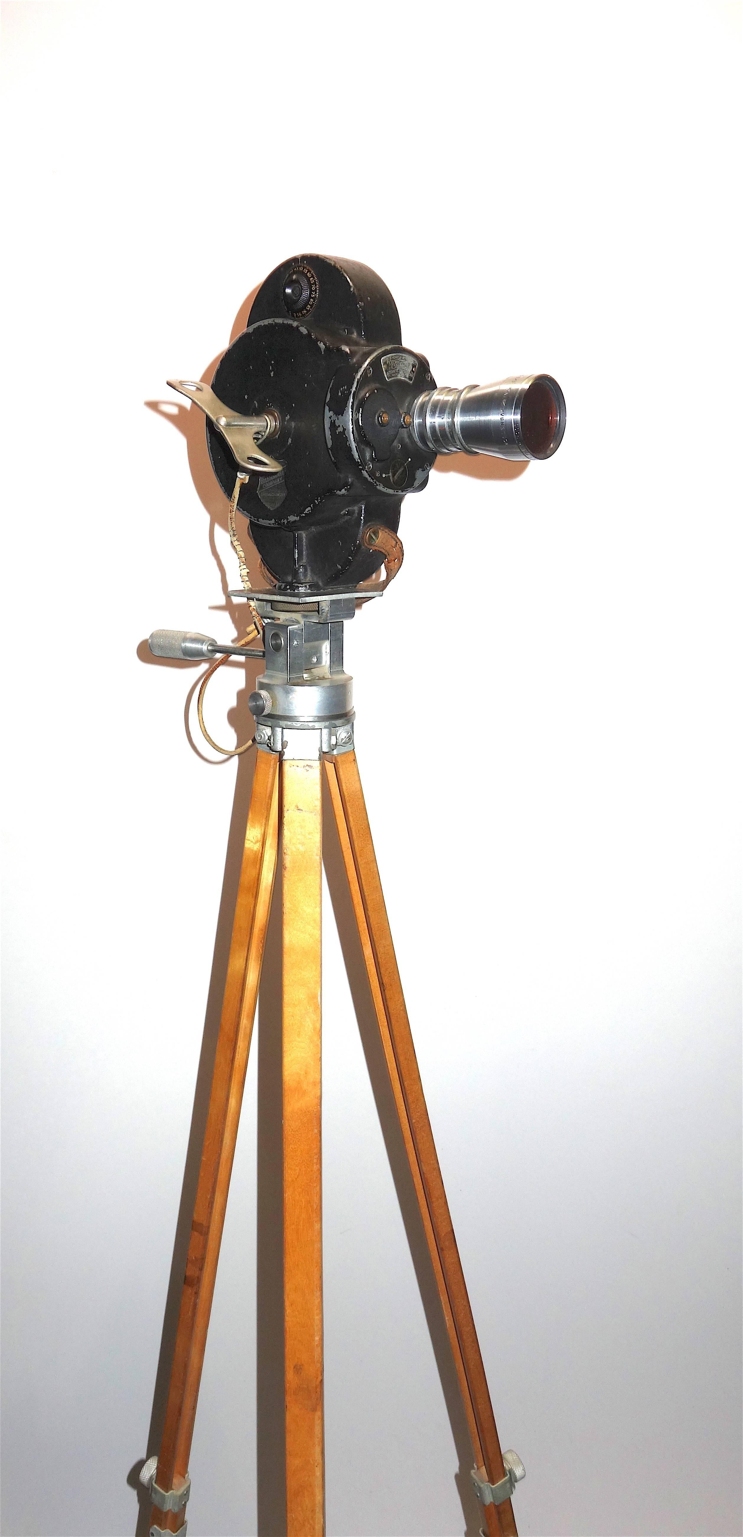 Industrial Hollywood Early 20th Century Movie Camera with Vintage Head and Wood Tripod Legs For Sale