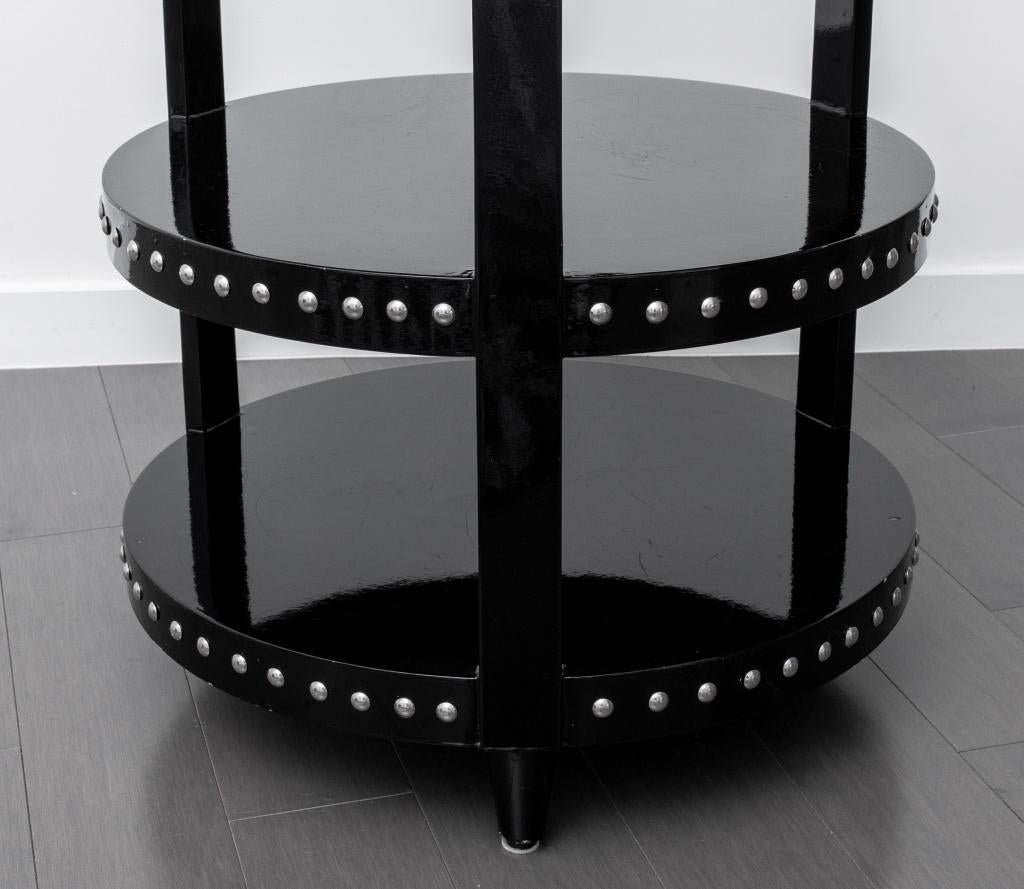 Three-tiered, black lacquered black lacquered drum table with silver nailhead accents. In good condition. Wear consistent with age and use. 
Dimensions: 26.5