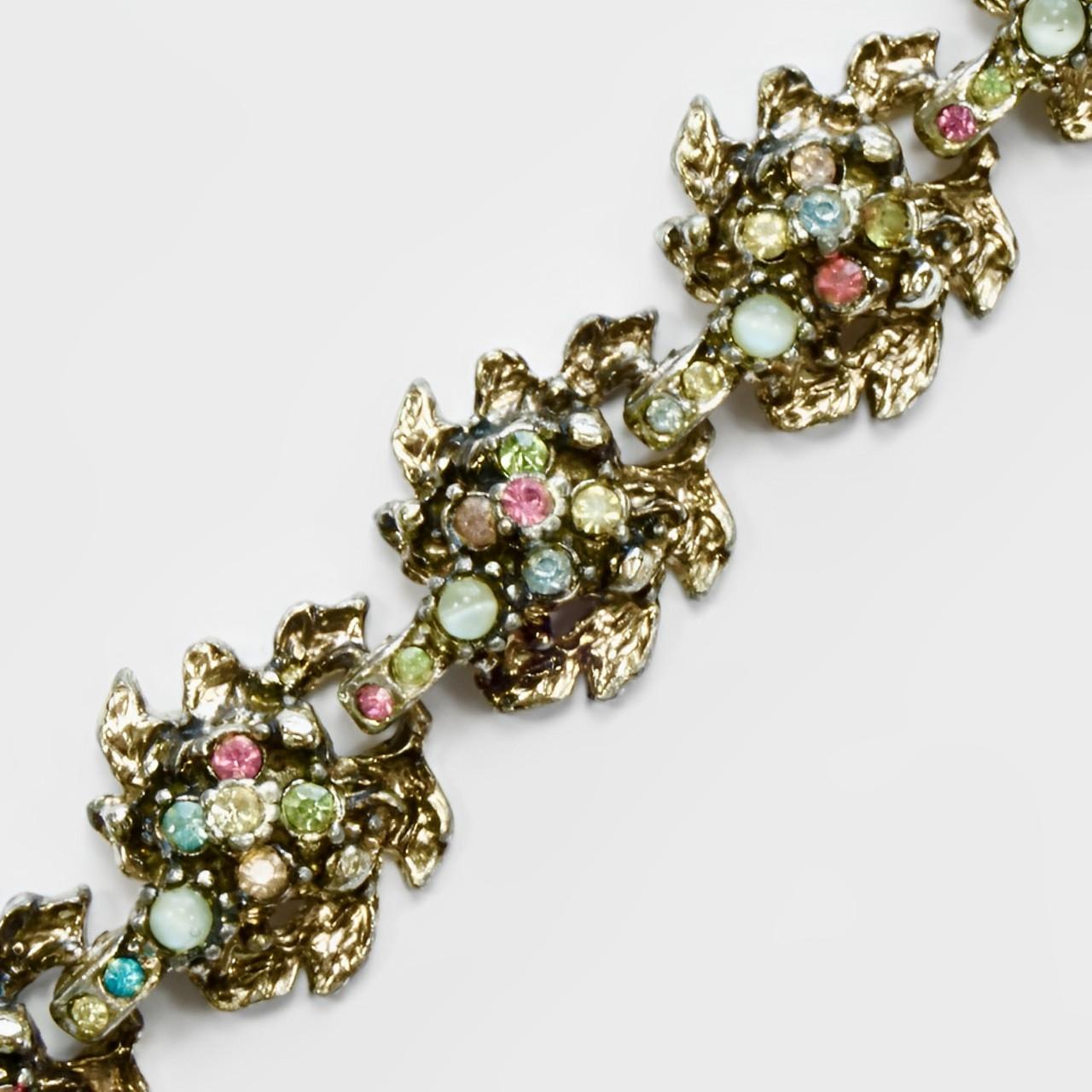
Hollywood fabuleux bracelet à maillons en plaqué or et émail noir, dans un ravissant motif de feuilles et de fleurs. Il est serti de strass multicolores. Longueur 17,3 cm / 6,8 pouces et largeur 1,9 cm / 0,74 pouce. La dorure est un peu usée. Le