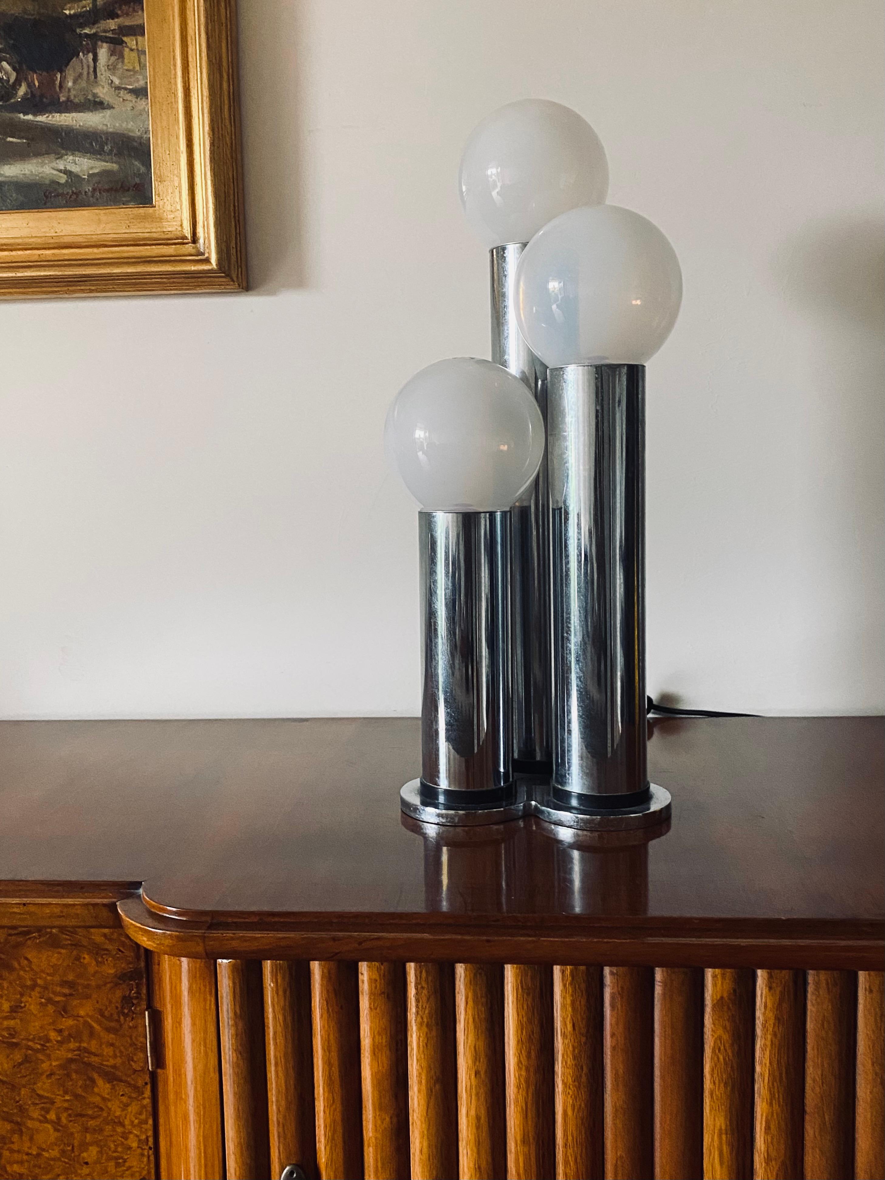 Lampe de table à 3 lumières en métal et verre opalin Hollywood regency 

Lama, Italie 1970

Métal chromé, verre opalin

H 53,5 x 25 cm diam.

État : excellent, conforme à l'âge et à l'utilisation. Petite brûlure sur un verre