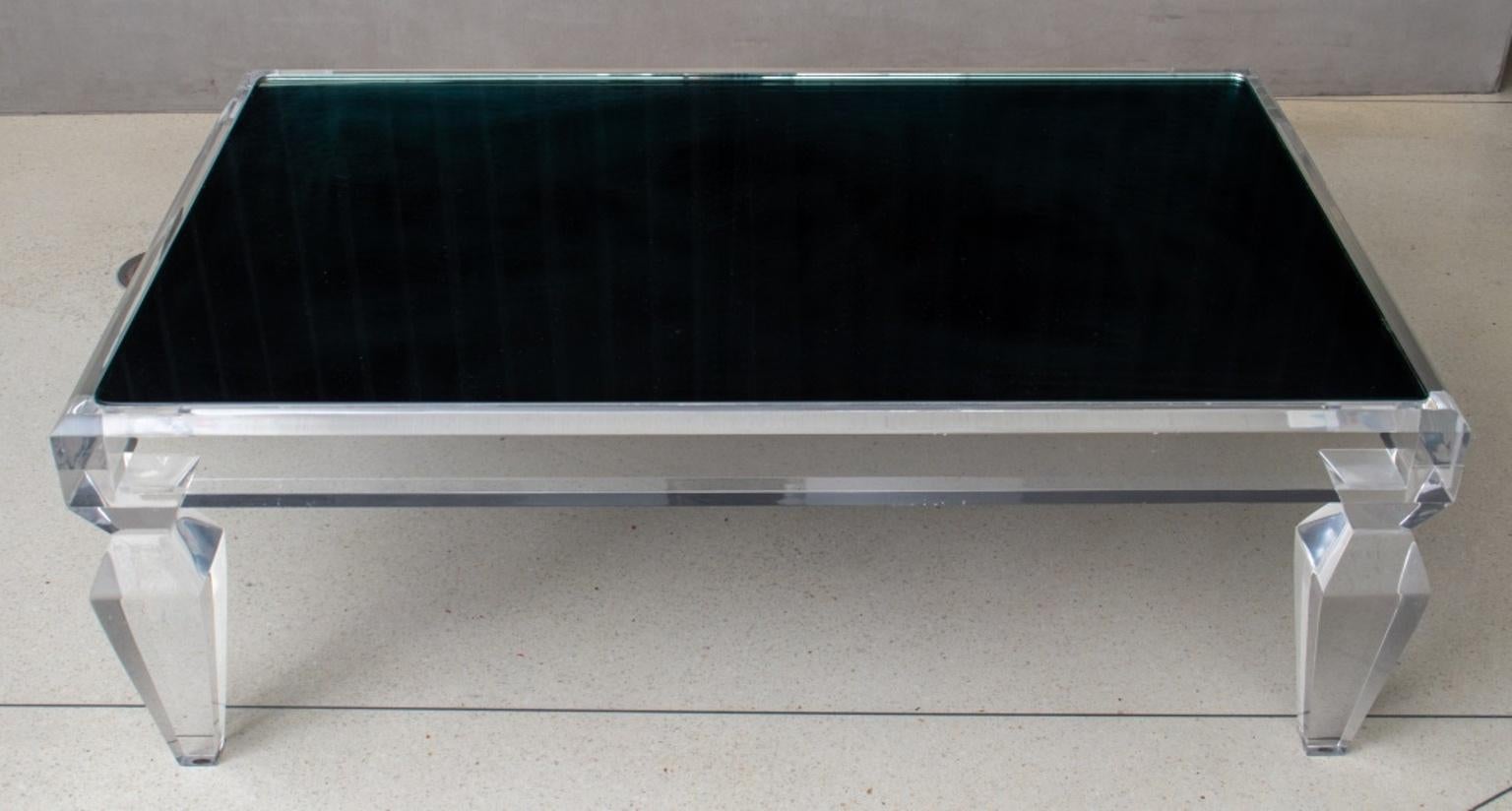 Hollywood Regency Revival low coffee table, with an inset antiqued mirror top, on four lucite legs. 17