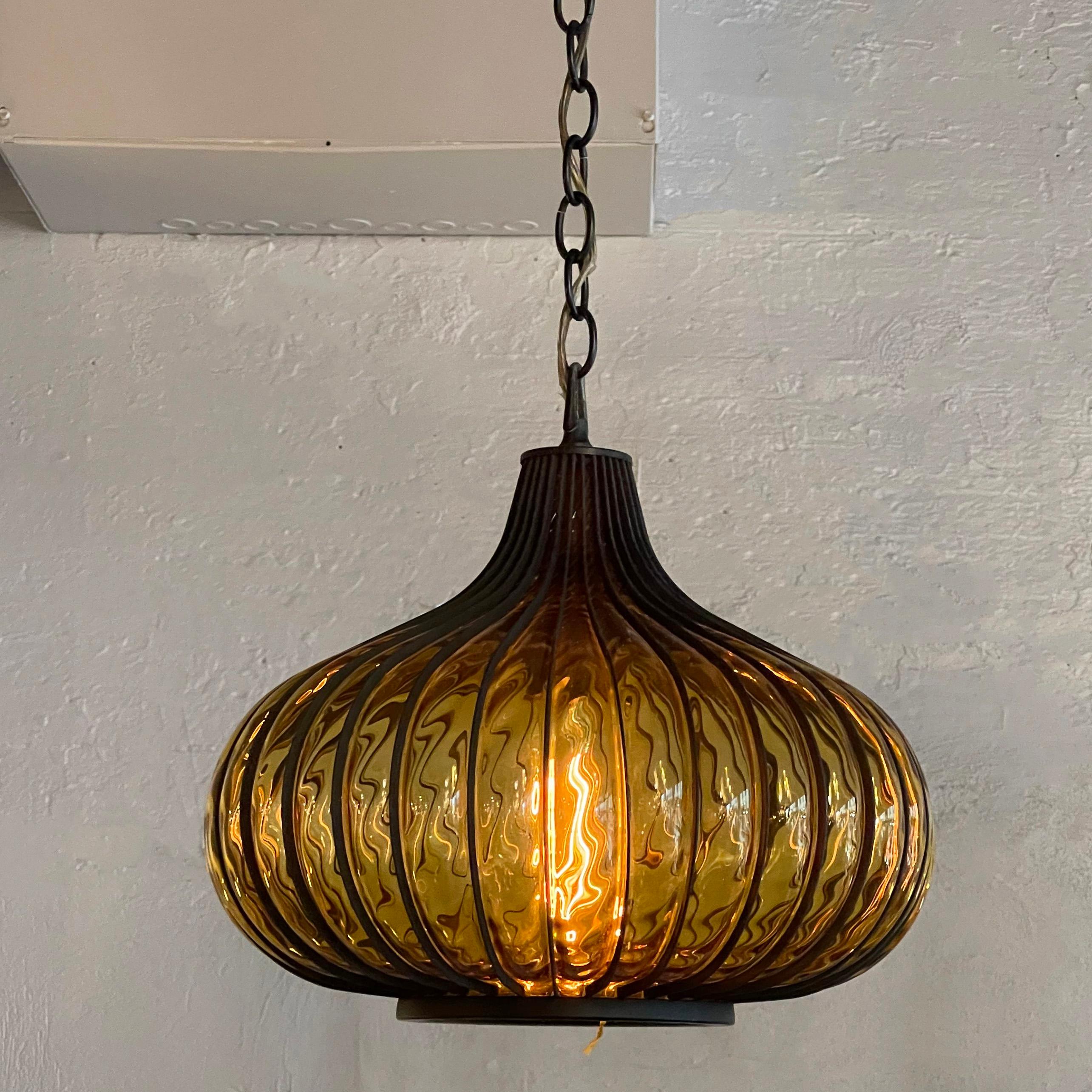 Midcentury, Hollywood Regency, onion-shaped pendant light features an amber glass shade blown into the metal cage frame. The pendant has approx 120 inches of chain to achieve a long swag. There is a string pull mechanisim inside the pendant to turn