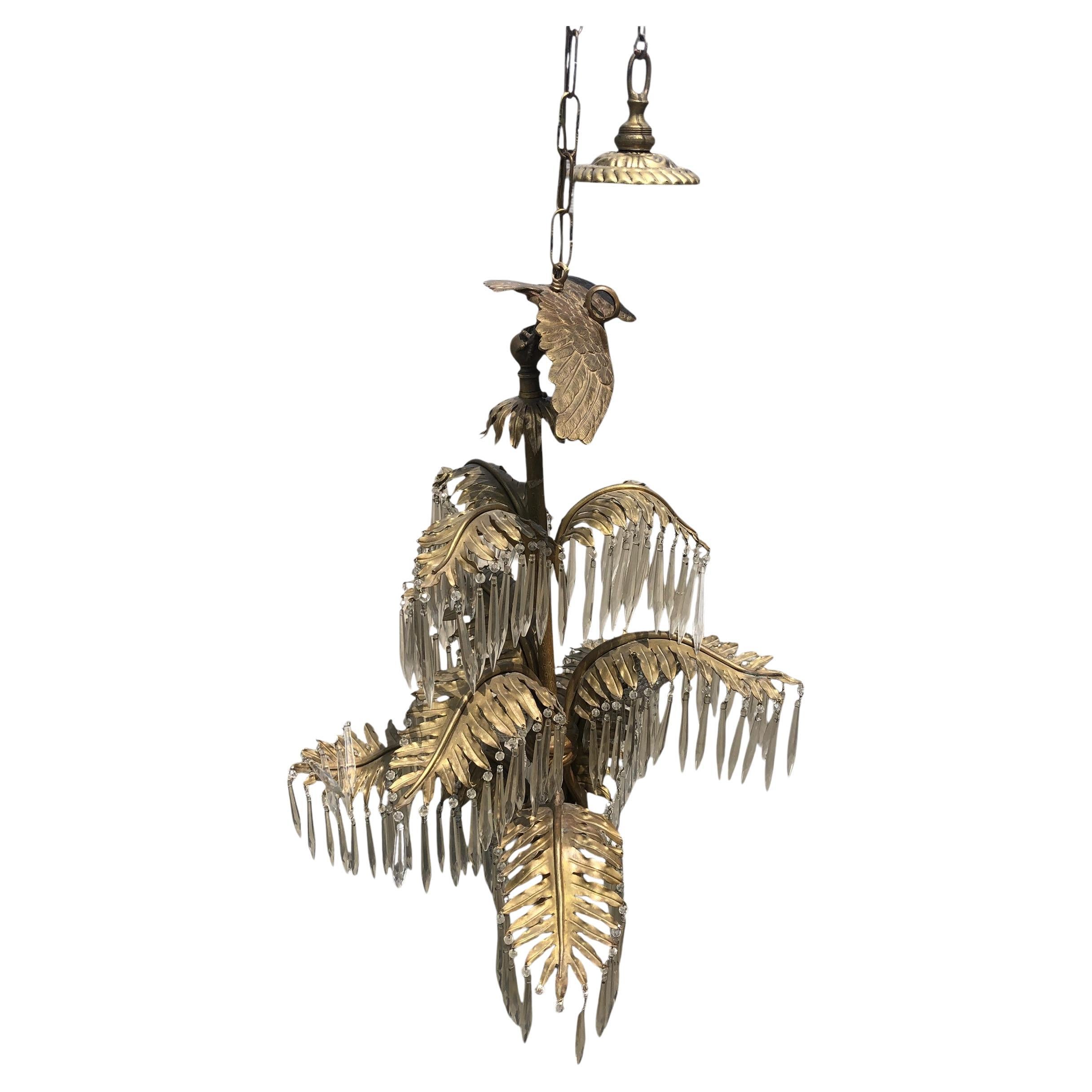 Un spectaculaire lustre en bronze et cristal taillé à trois niveaux de palmiers, de qualité exquise, de l'époque Hollywood Regency. Conçue sous la forme d'un palmier et agrémentée de  Les feuilles de palmier en bronze sont ornées de prismes en