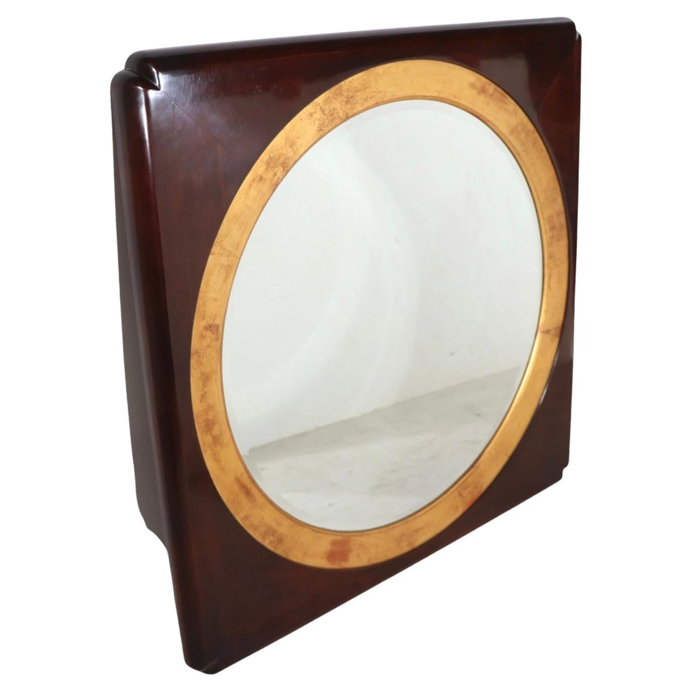 Spectaculaire miroir hublot réalisé par Henredon, fabricant de meubles de qualité supérieure, vers les années 1970/1980. Le miroir présente un centre circulaire, (32 pouces de diamètre), entouré de garnitures dorées, dans un cadre en bois foncé
