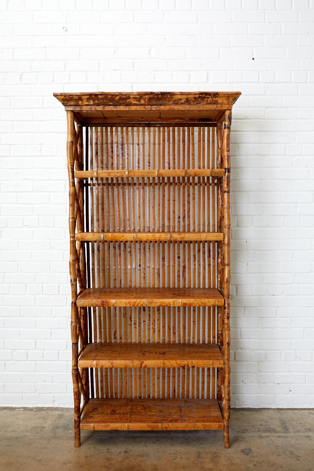 Gorgeous bamboo rattan five shelf étagère or bookcase made in the Hollywood Regency period. Beautifully crafted with tortoise style bamboo poles and a corniced top. Features X-form supports on the sides. Each shelf is decorated with split bamboo and