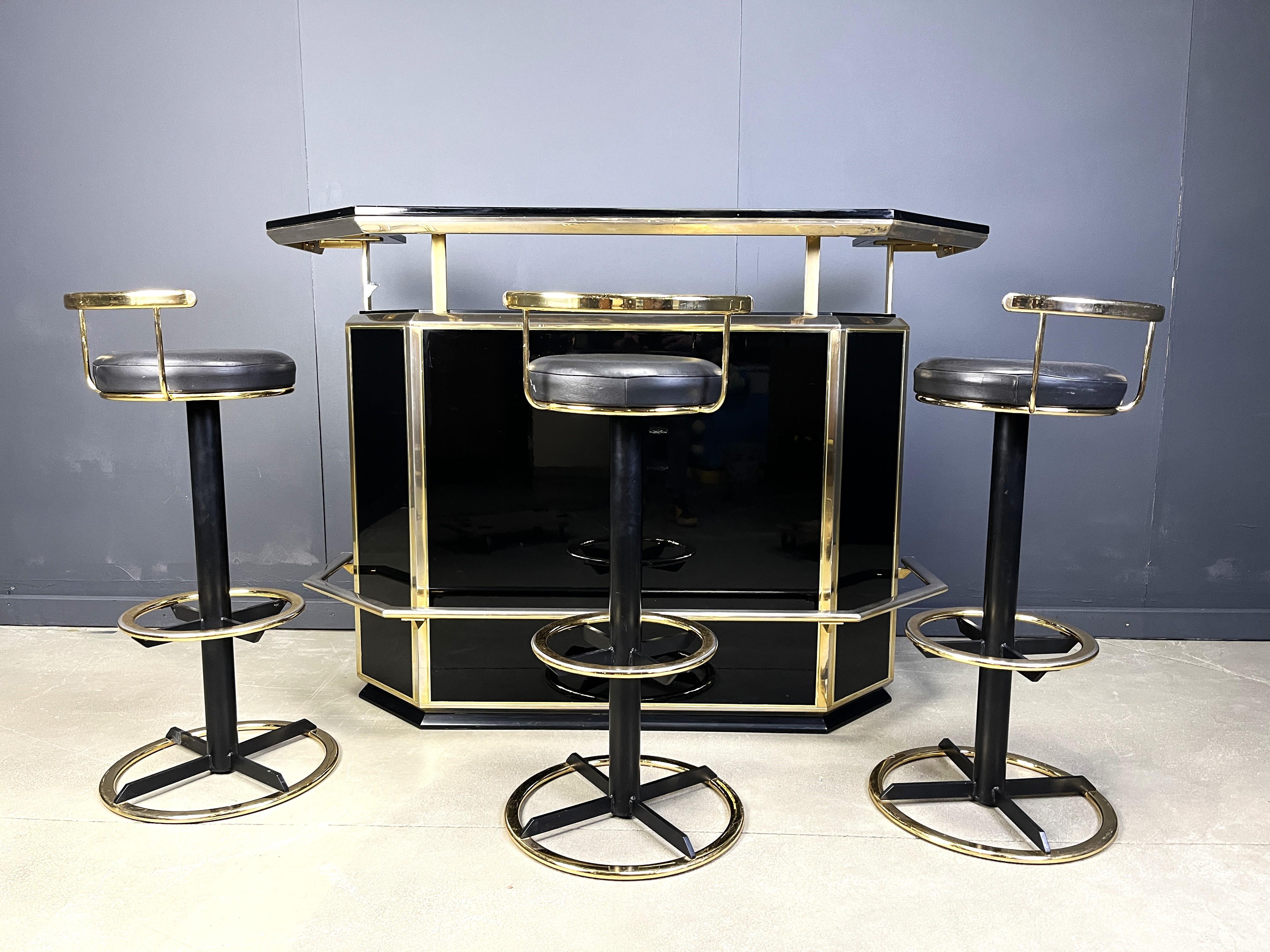 Bar sec vintage avec trois tabourets de bar en bois laqué et laiton.

Le bar comporte deux portes, un espace de rangement central et trois tiroirs offrant un vaste espace de rangement ainsi qu'un grand plateau flottant.

Cet objet attire l'attention