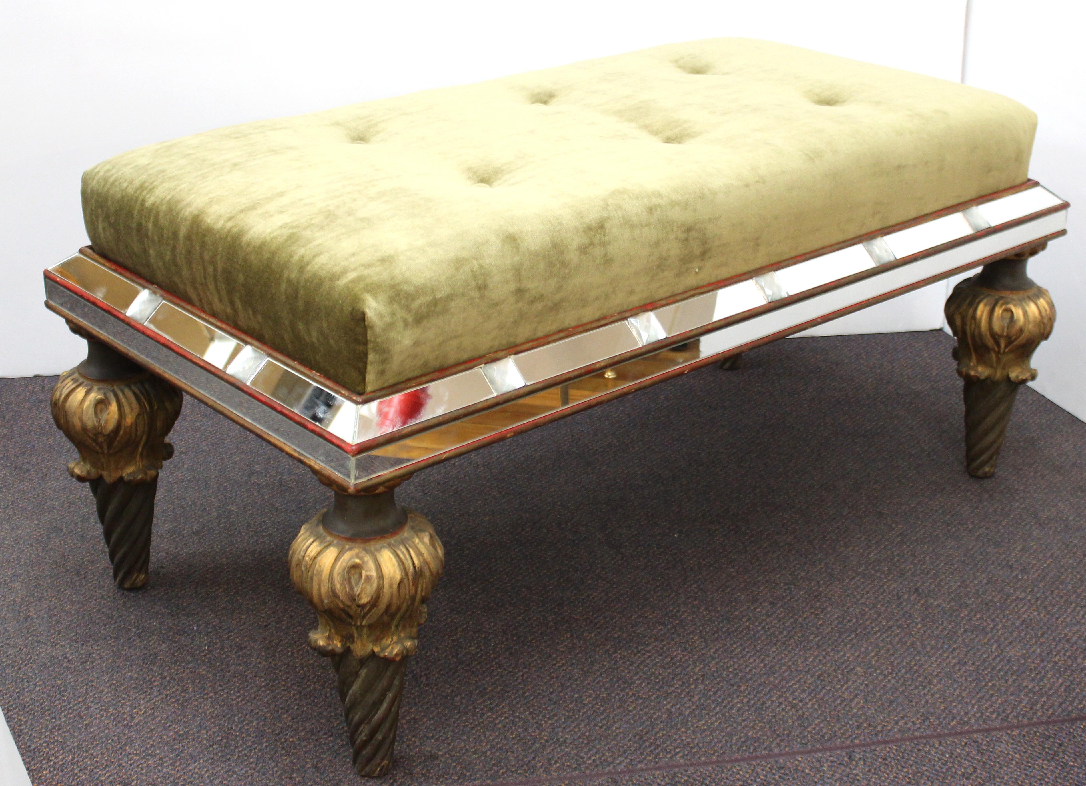 Italian Hollywood Regency bench with mirrored frame and hand carved, partially gilt and painted legs and recently reupholstered seat in light olive-green linen velvet. The piece was made during the 1940s in Italy and is in great vintage condition.