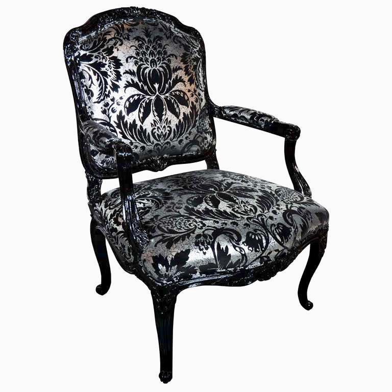1920s Louis XV style bergere chair with a high-gloss black lacquer finish. Upholstered in a vintage damask velvet by Andrew Martin, featuring metallic silver foil embossed with black velvet motifs. The reinterpreted design gives this antique chair a