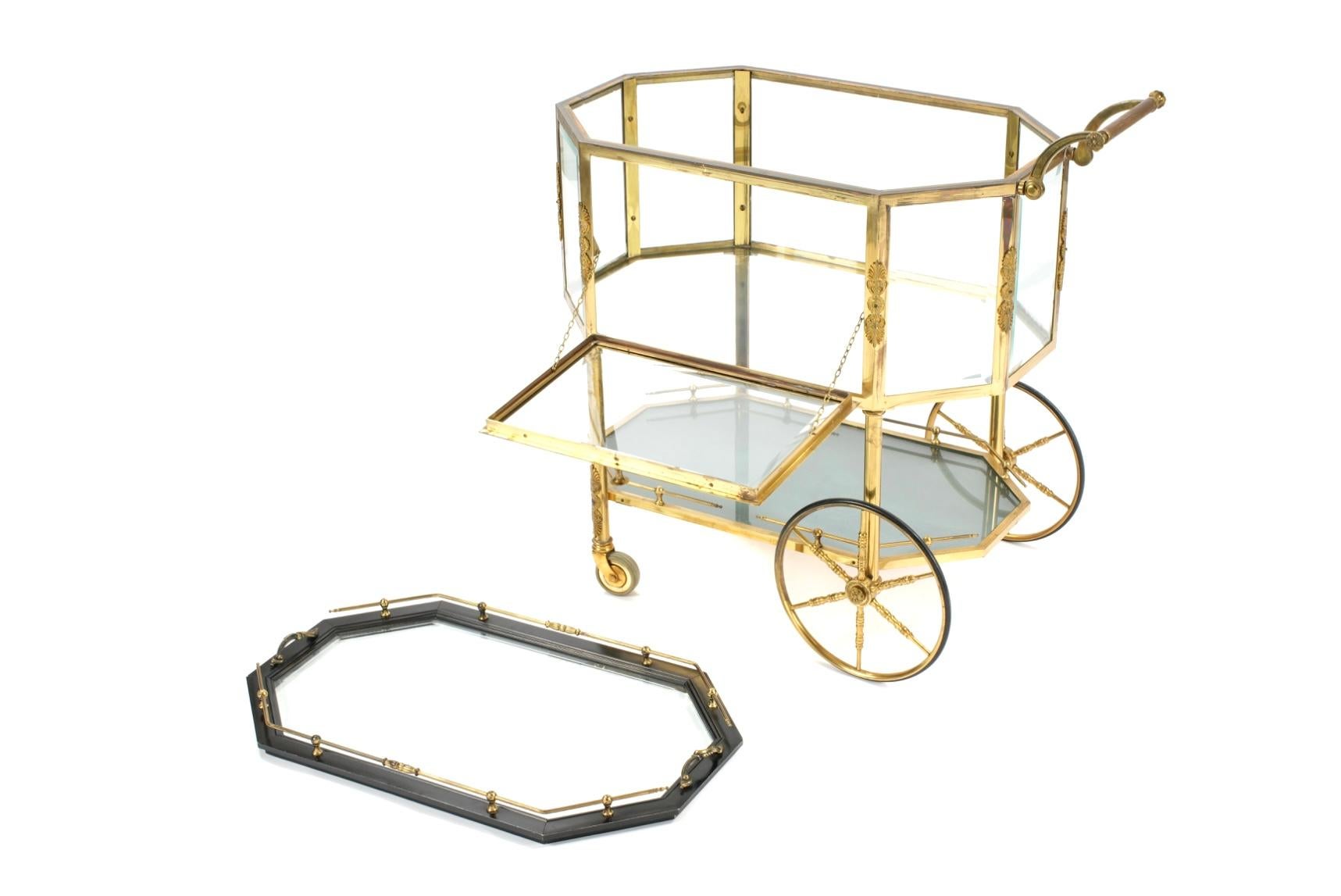 Mid-Century French Tea Bar Trolley Cart. This finely crafted bar cart features a removeable tray top, a fall-front glass door that opens to a vitrine compartment for display or storage, and a brass gallery surrounding the upper tier. Decorative