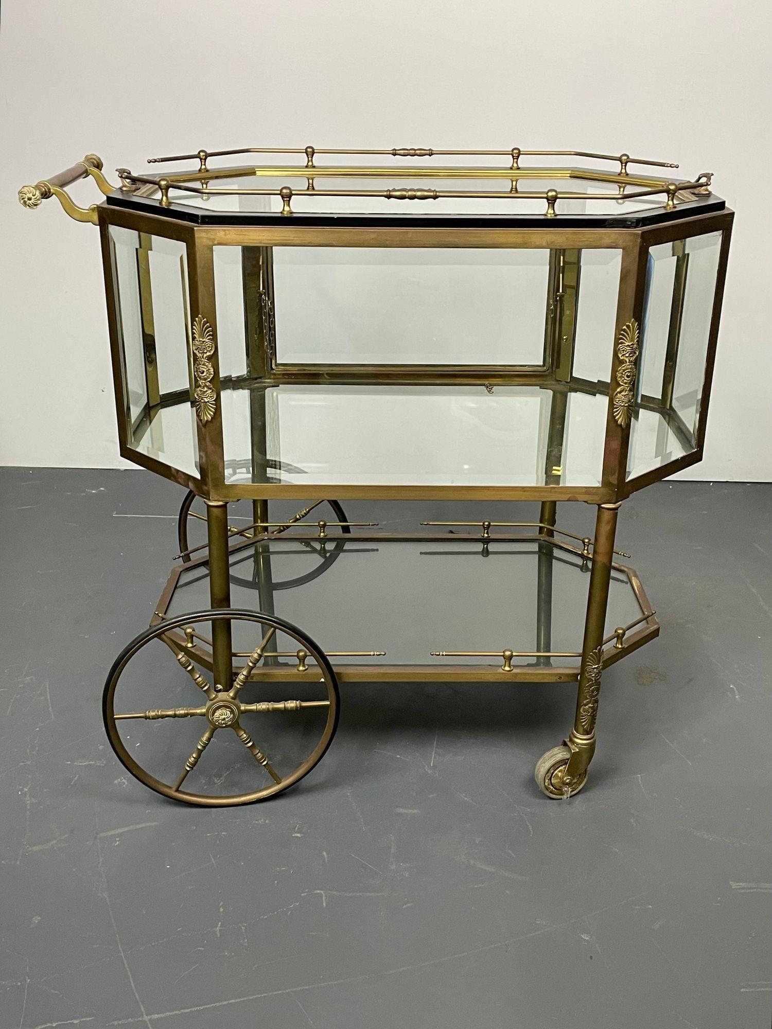 Hollywood Regency Beveled Glass, Bronze and Brass Tea Wagon or Serving Cart
Beveled glass and bronze tea wagon or serving cart. This wonderful Hollywood Regency style cart has small wheels in front with large wheels in back supporting a brass and