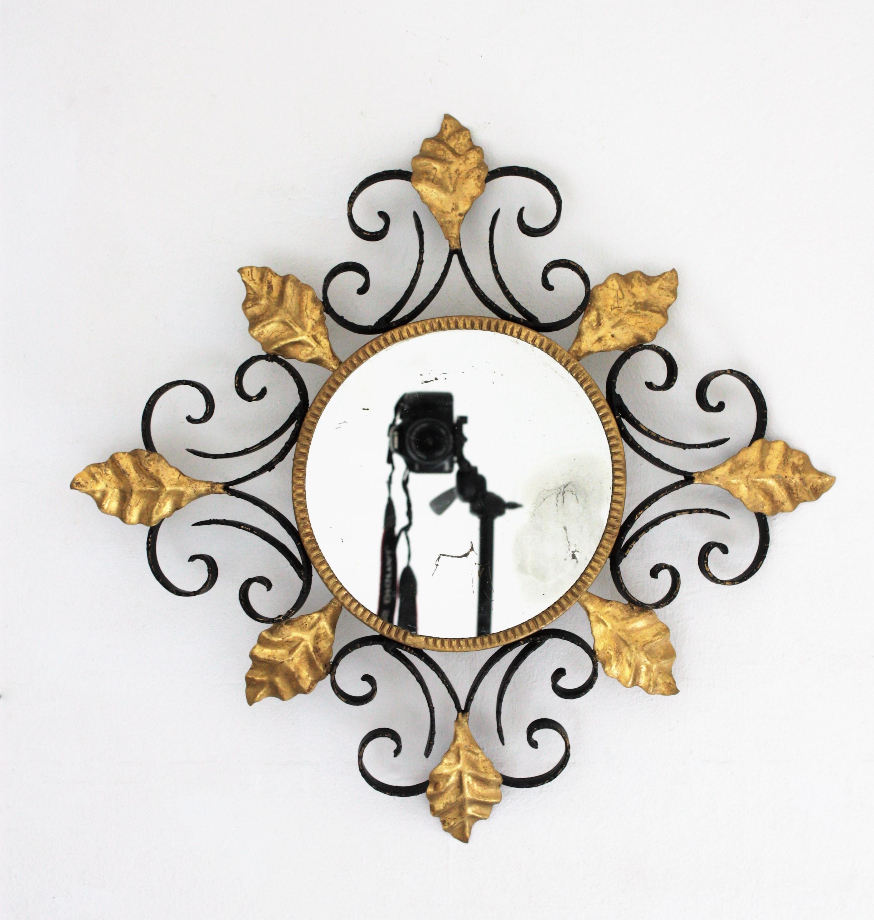 Amazing hand-hammered iron black and gilded scroll motif leafed light fixture / sunburst mirror. Spain, 1950s.
Scrollwork patinated in black color accented by gold leaf gilt leaves.
The contrasting effect between black and gilt iron highlights the