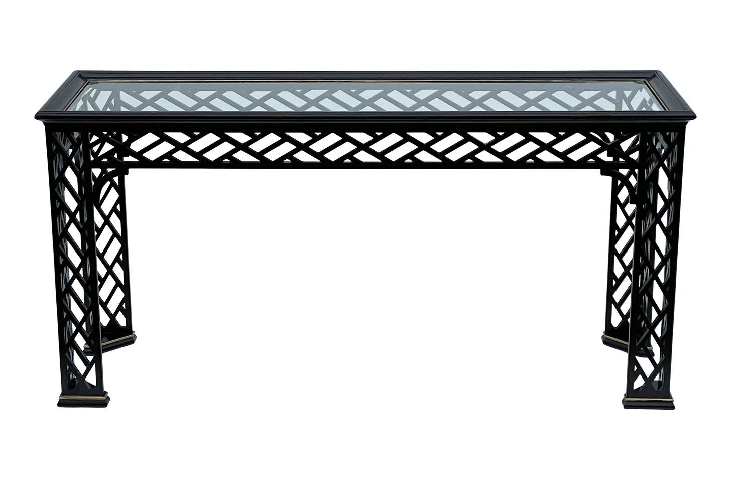 A stunning & intricate console table circa 1980's. It features black wood base, inlayed glass, with brass details. 