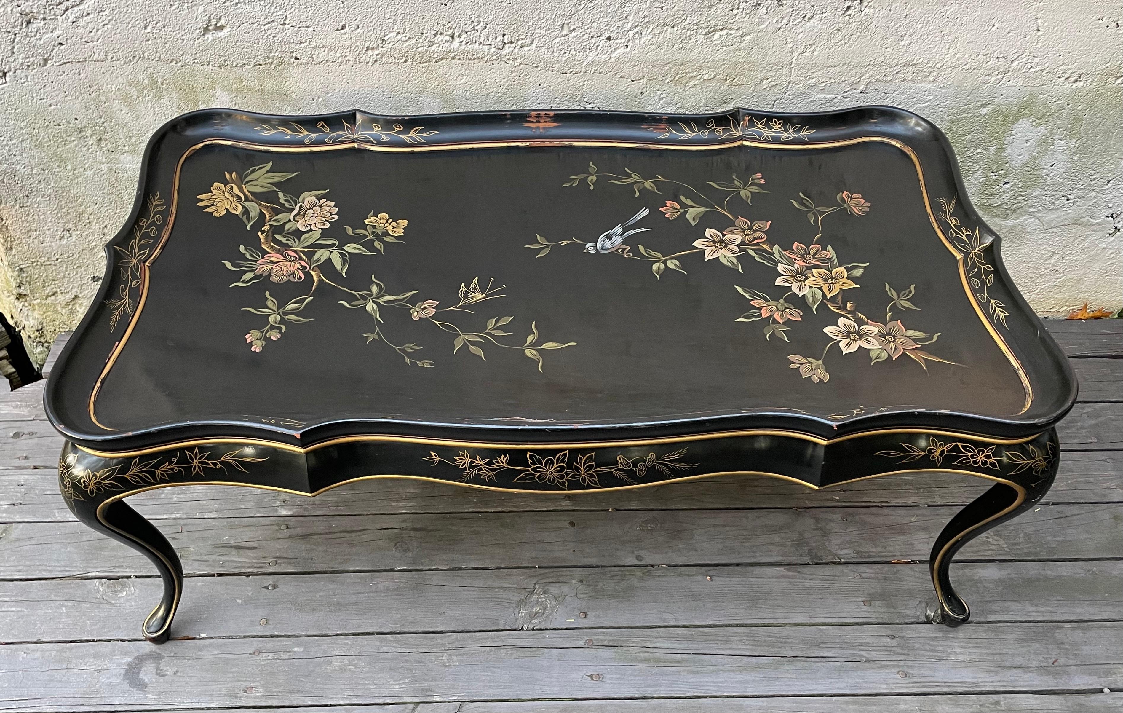 Beautiful Hollywood Regency Japanese black lacquered coffee table with hand painted floral design. Curved tray top with lovely curved legs, all original.